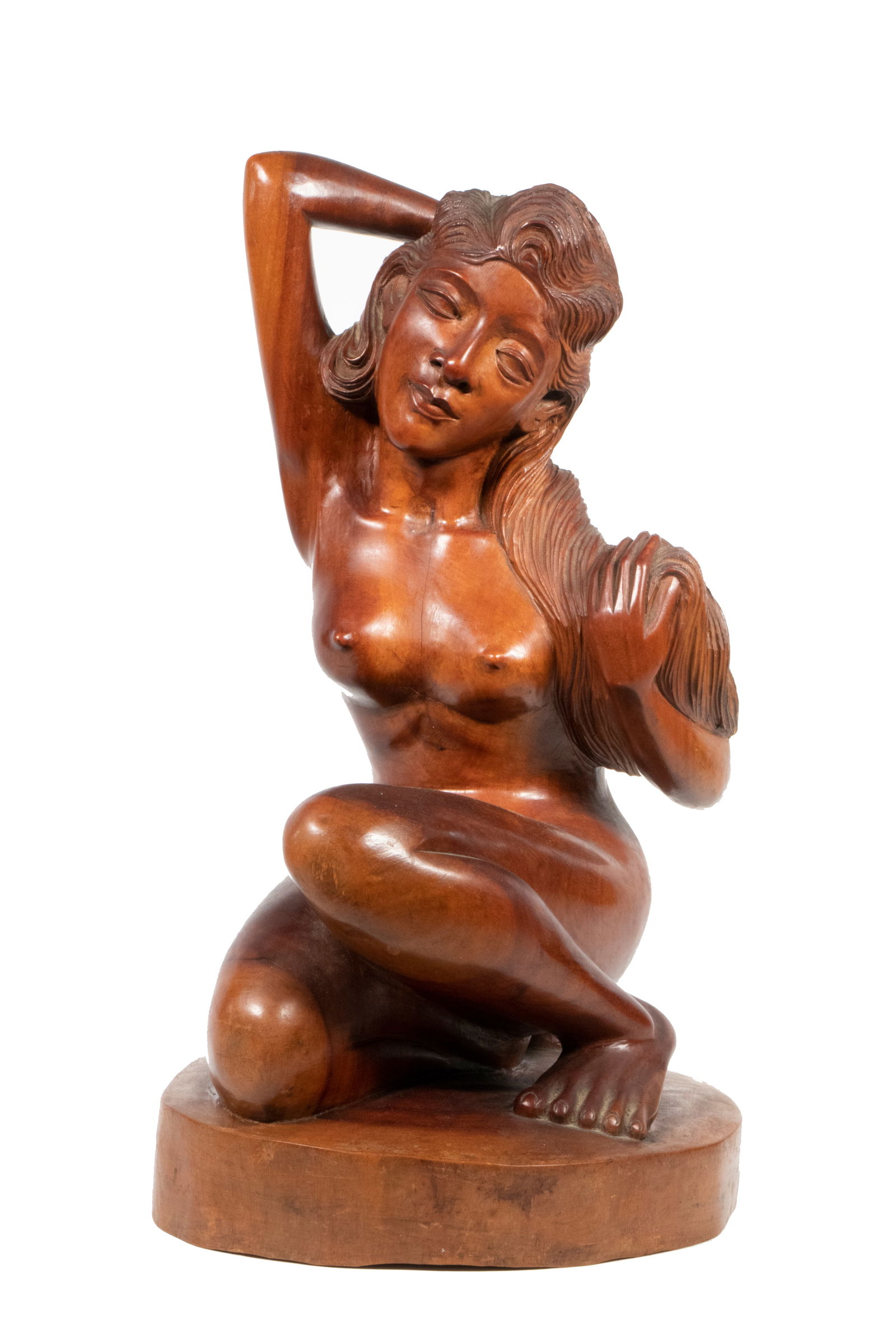 FILIPINO WOOD CARVING: FILIPINO WOOD CARVING Figure of a Nude Woman, kneeling, with one hand behind her head, the other grasping her hair, from a single section of teak, having an integral round plinth, unsigned, probably
