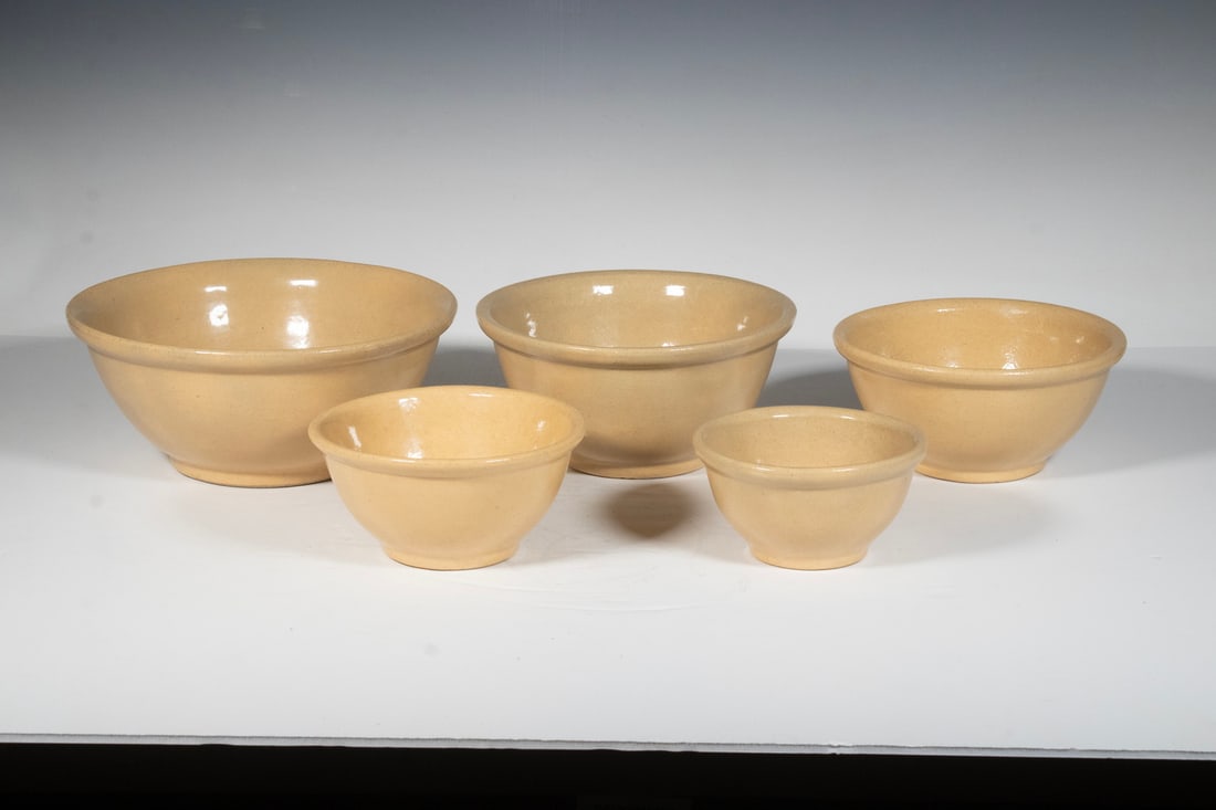 (5) NESTING AMERICAN STONEWARE MIXING BOWLS, C. 1920s: (5) NESTING AMERICAN STONEWARE MIXING BOWLS, C. 1920s A graduated set of five utilitarian stoneware mixing bowls, wheel-thrown with ochre glaze and unglazed foot rims. Likely American, 1920s. LGST: 4