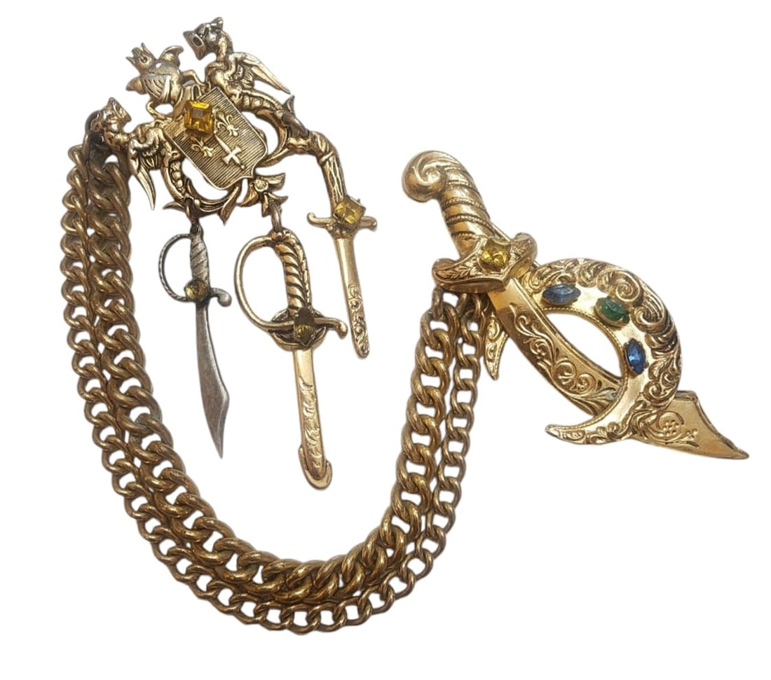 Vintage heraldic coat of arms chatilane brooch with dangling swords: Well made, unsigned, beautiful detailing, a teeny drop of verdigris behind the pin hinge and rollover clasp on the large sword,9" in length. WE OFFER IN-HOUSE SHIPPING VIA UPS AS WELL AS LIVE SHIPPING