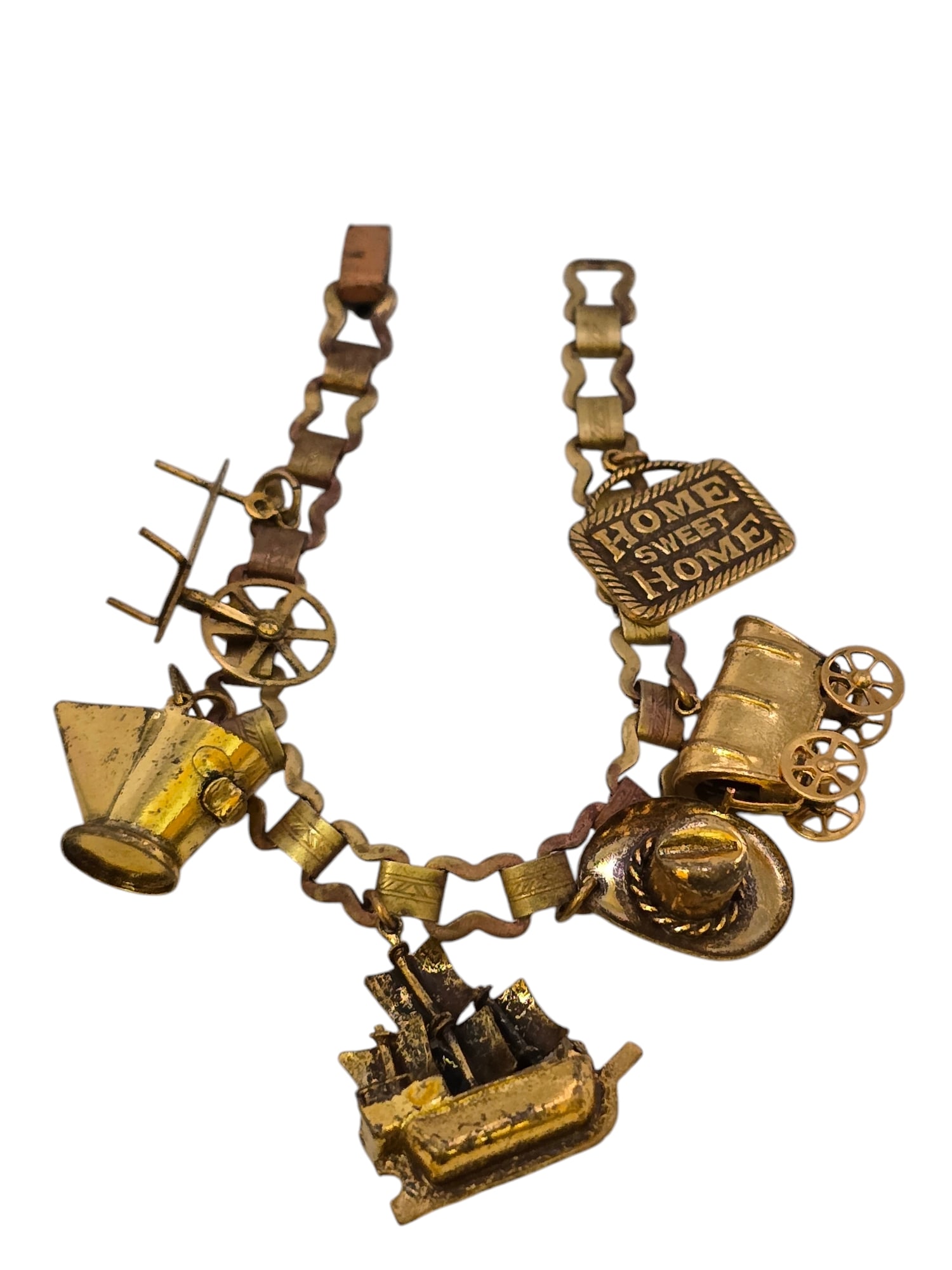 VINTAGE ANTIQUE CHARM BRACELET WITH WESTERN FEEL: VINTAGE ANTIQUE CHARM BRACELET WITH WESTERN FEEL, 8". IN GOOD CONDITION, BRASS CHAIN HAS SOME DARKENING AND THE TOP OF FOLDOVER CLASP IS DARK. WE OFFER IN-HOUSE SHIPPING AS WELL AS LIVE SHIPPING AND L