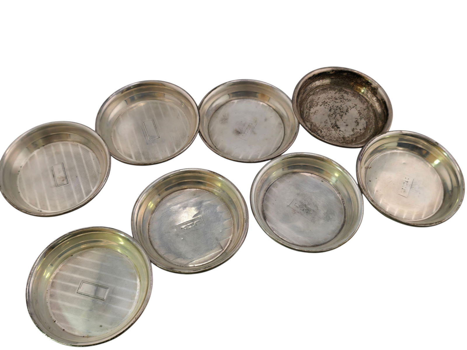 VINTAGE SET OF 8 INITIALED SMALL STERLING COASTER: VINTAGE SET OF 8 INITIALED SMALL STERLING COASTER. 2.5". THEY HAVE A DESIGN. A FEW ARE FADED, 1 IS VERY TARNISHED. SOME INITIALS ARE FADED. WEIGHS 142.04 GRAMS.