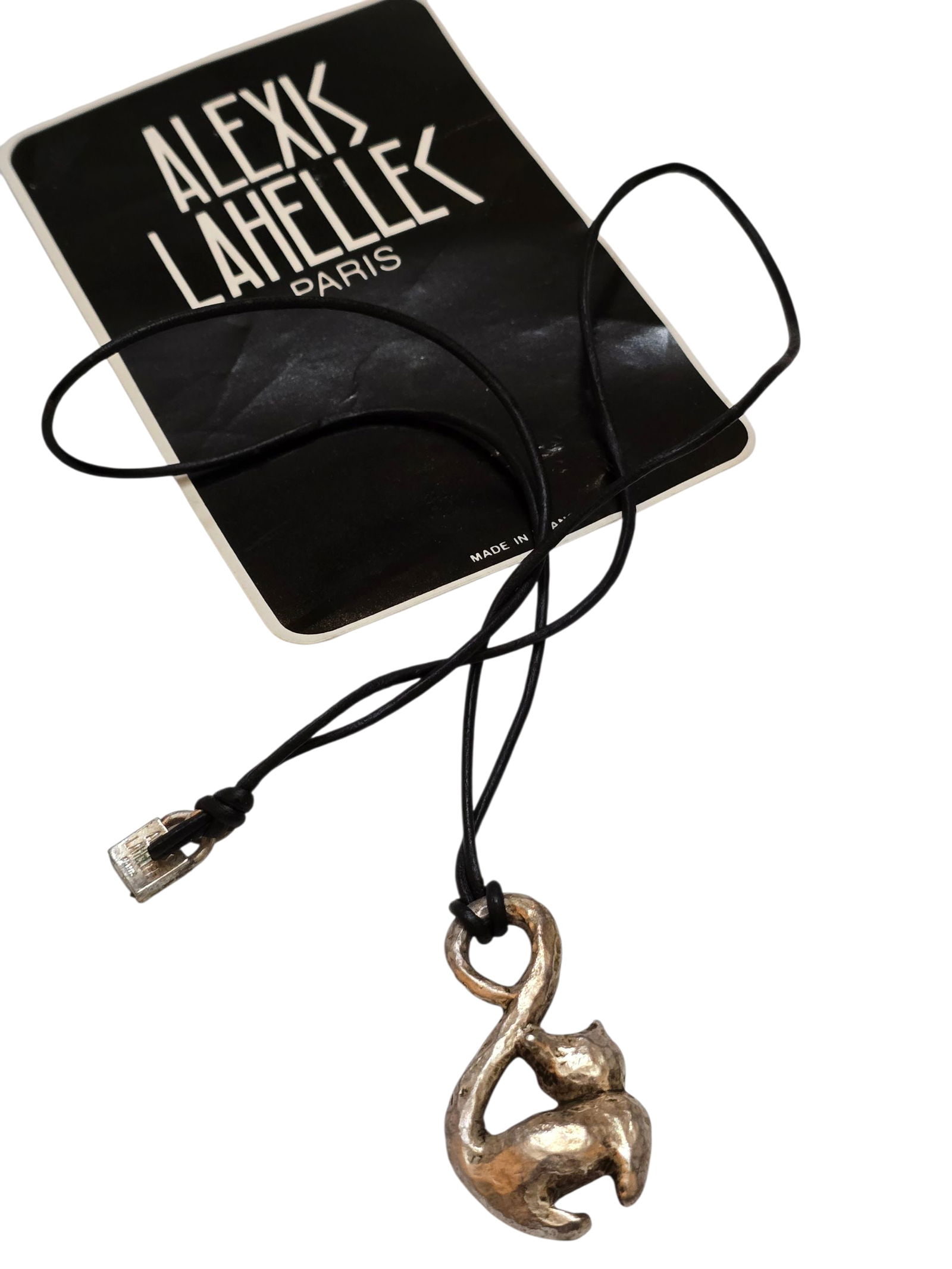 VINTAGE 80S RARE ALEXIS LAHELLEC PARIS NOS METALIZED PLASTIC SILVERTONE CAT CHARM ON LEATHER CORD: VINTAGE 80S RARE ALEXIS LAHELLEC PARIS NOS METALIZED PLASTIC SILVERTONE CAT CHARM ON LEATHER CORD NECKLACE. 24", IN VERY GOOD CONDITION. HAS SIGNATURE LOCK AT BACK. WITH CARD. This is a New Old Stock