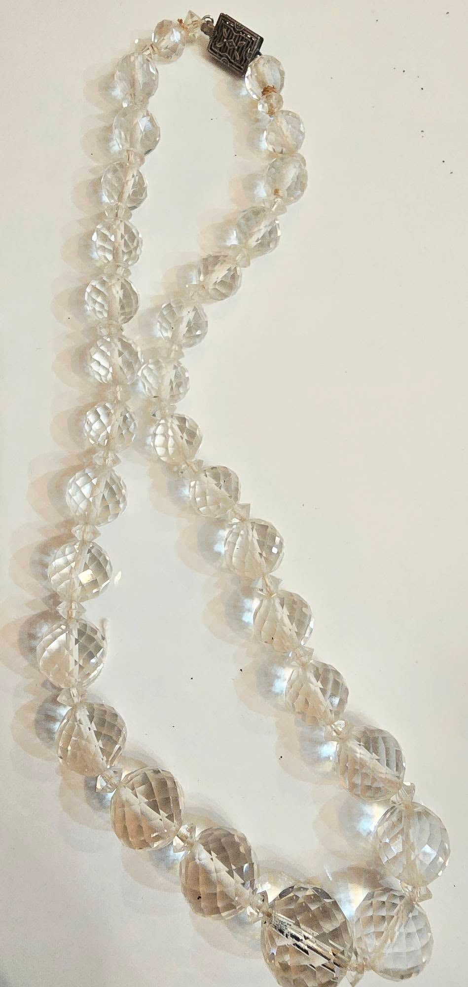 ANTIQUE FACETED CRYSTAL OR POSSIBLY ROCK CRYSTAL NECKLACE: ANTIQUE FACETED CRYSTAL OR POSSIBLY ROCK CRYSTAL NECKLACE. THEY ARE BEAUTIFULLY FACETED, AND HEAVY, ART DECO FANCY PUSH IN CLASP, THERE'S A SMALL PIECE OF THREAD STICKING OUT, ALMOST 16"