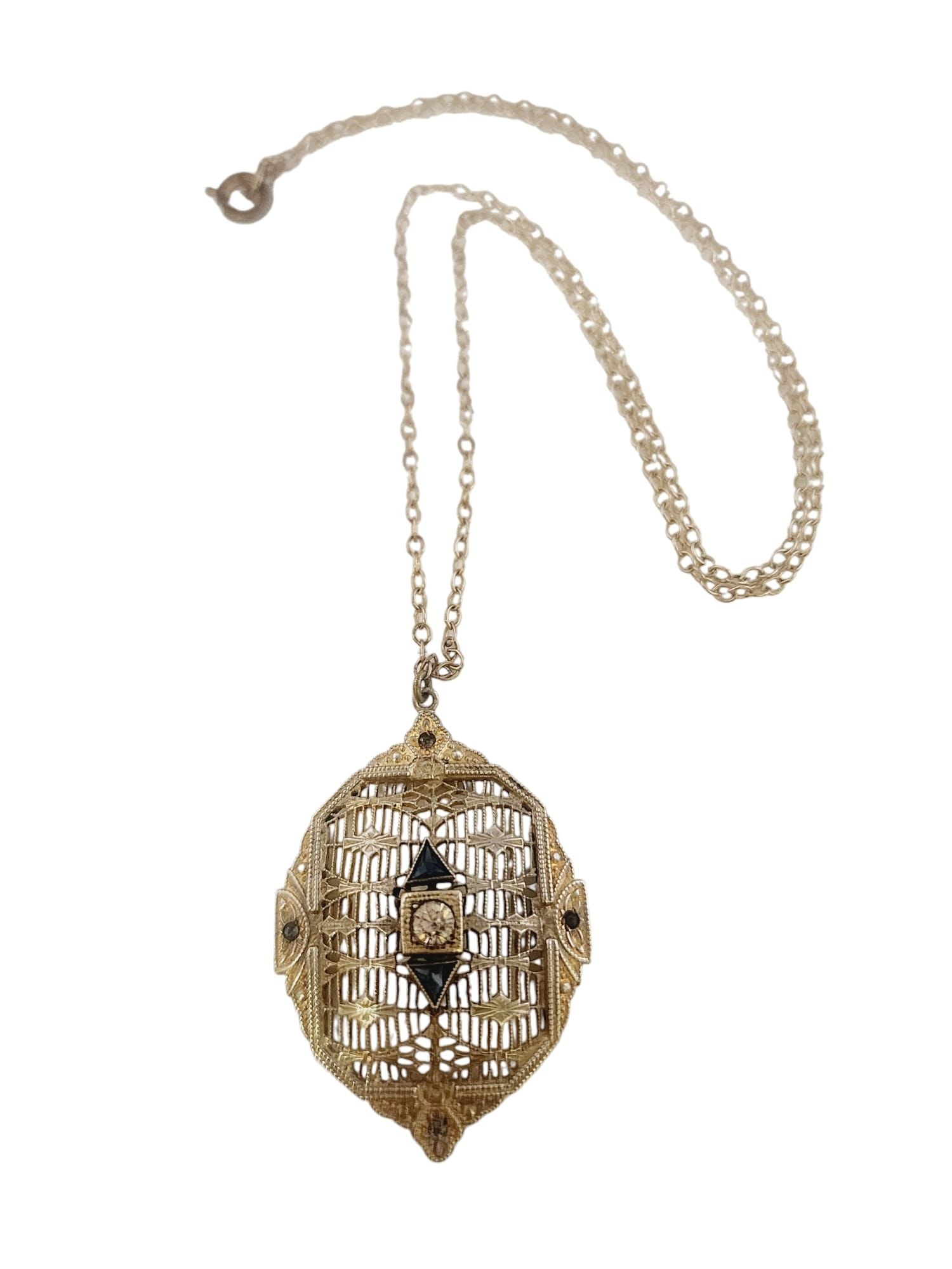 STUNNING EDWARDIAN PIERCED FILIGREE PENDANT NECKLACE: Stunning Edwardian Pierced Filigree Pendant Necklace. Pendant: 1.5" Chain: 16". Rhodium plated pendant, chain is a light silver tone. Clasp has turned brass tone. I believe all is original. I did not