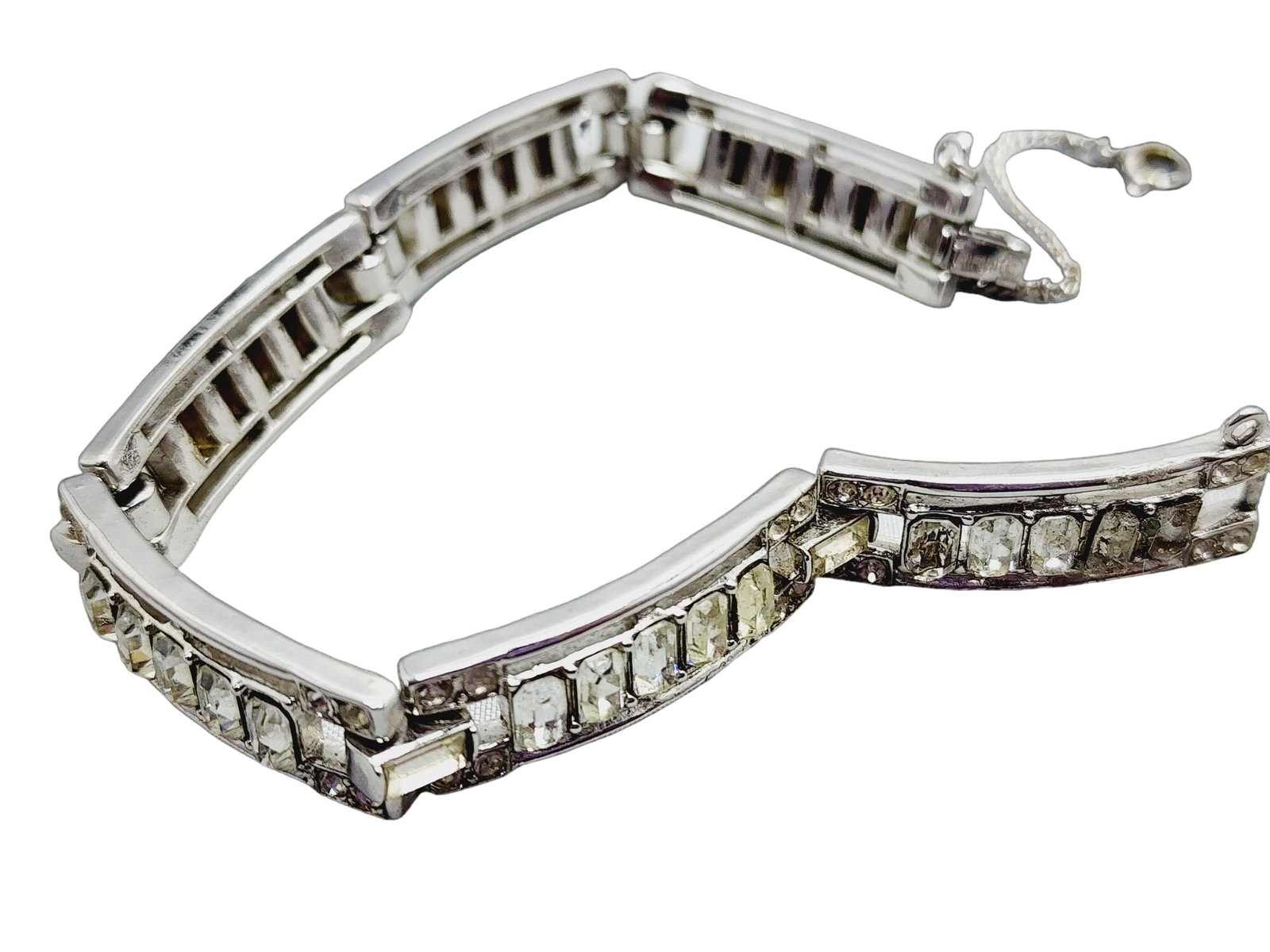 Vintage Trifari Signed Art Deco Jeweled Bracelet: Vintage Trifari Signed Art Deco Jeweled Bracelet (A1172) Size: 7" Color: clear, silver Condition: Good vintage; the first 2 square baguette stones, close to the end without a chain, have been either r