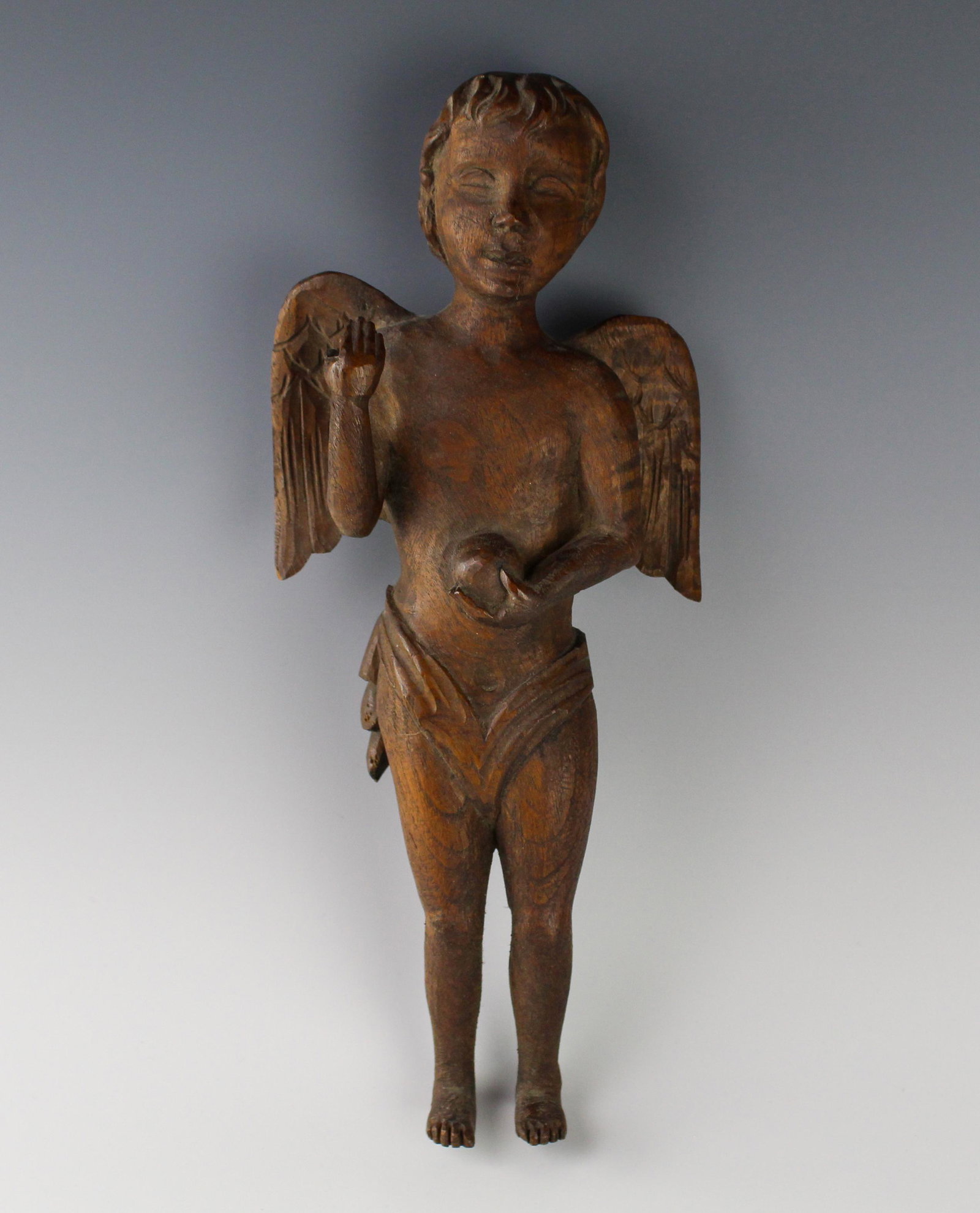 Hand Carved Antique Wood Cherub Putti Angel Statue: Well carved standing winged semi-nude cherub putto angel, modeled in a pose to suggest the Salvator Mundi (Latin: "Savior of the World"), a subject in religious iconography, his right hand raised in b