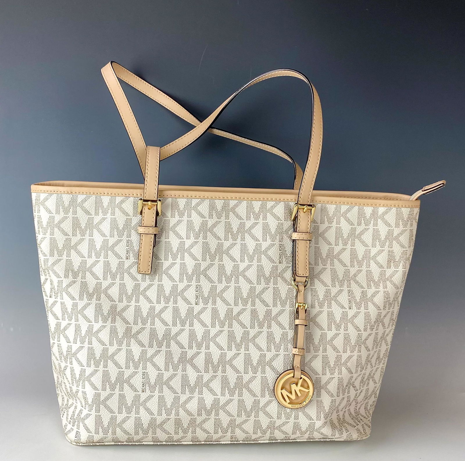 Michael Kors MK Logo Canvas Leather Tote Purse Bag: Features this tote bag with top handle straps, a front logo charm, stitched borders, a single zip top closure, large flat zippered pocket on one side, 2 slip compartments on the opposite side. No dust