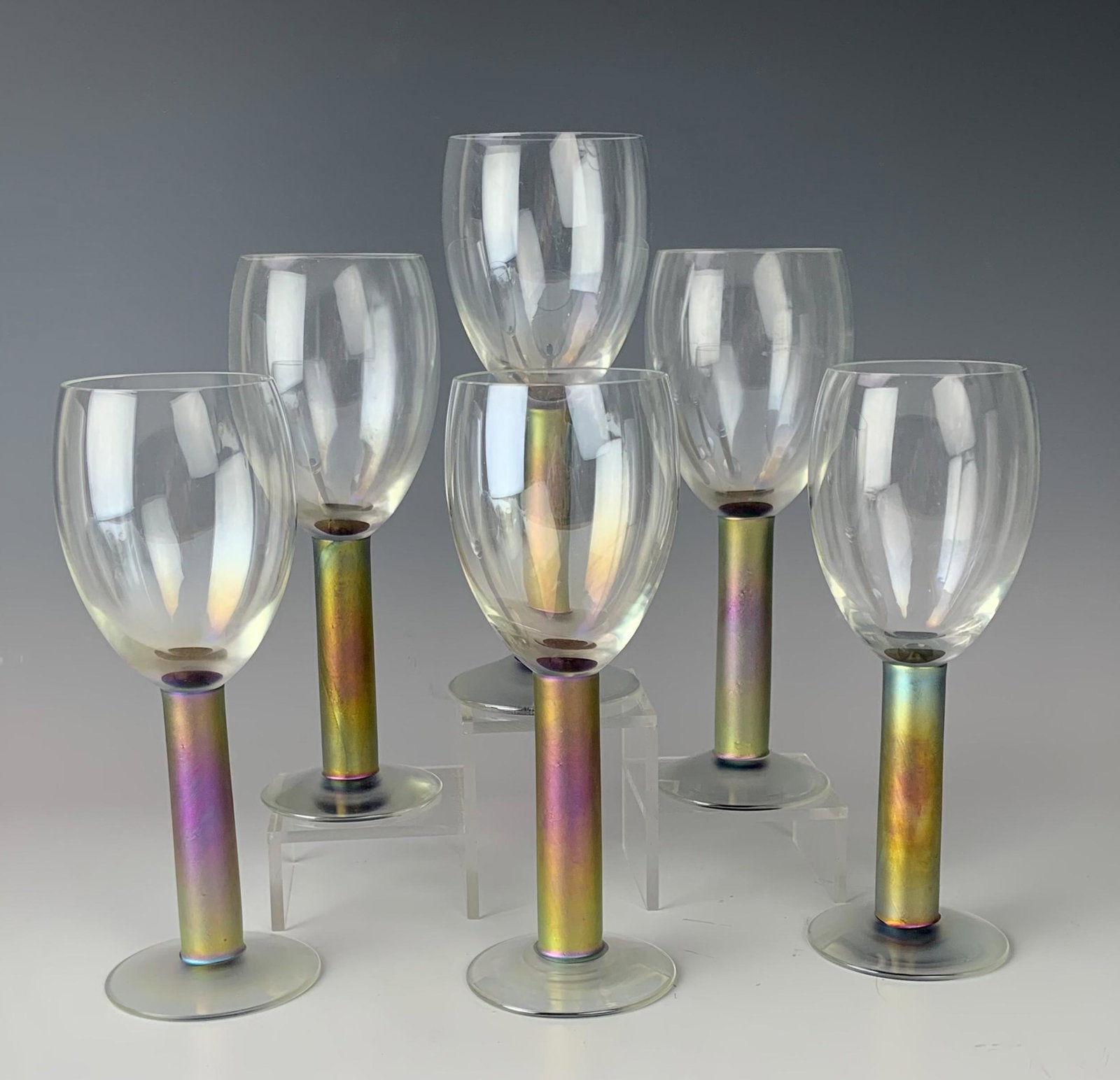 Set 6 Steven Maslach Aurene Iridescent Wine Goblet: Painstaking hand crafted and mouth blown in manner by San Francisco native glass sculptor / artist Steven Maslach. Each goblet graced with a clear bowl affixed to an iridescent solid stem over a sprea