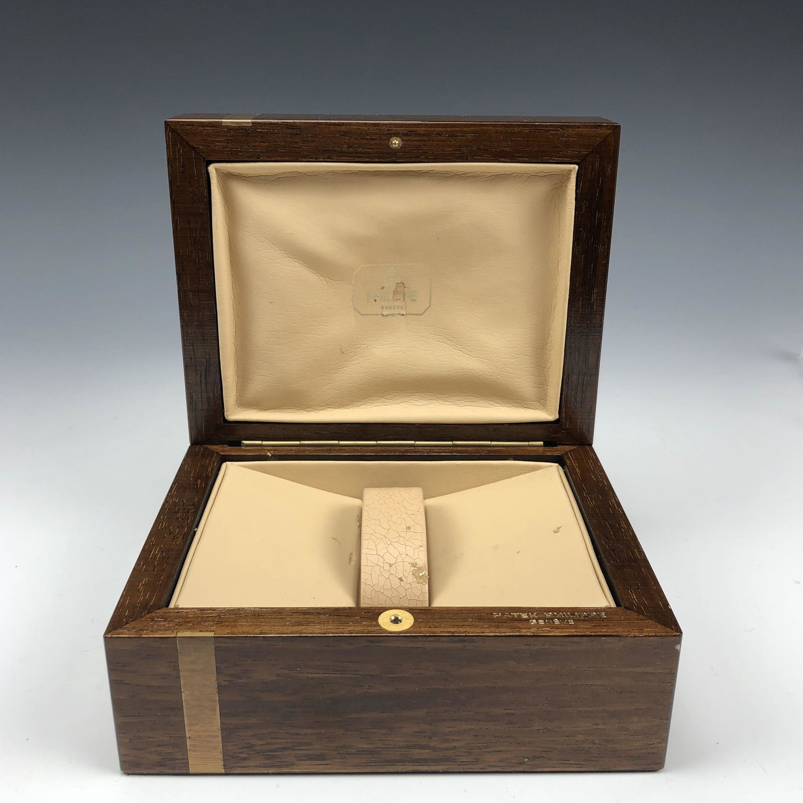 Patek Philippe Geneve Watch Presentation Wood Box: Genuine Patek Philippe Geneve Presentation Wrist Watch Box. High polished finish and the contrasting lighter colored wood band add further visual appeal. Interiors with a soft beige colored leather li