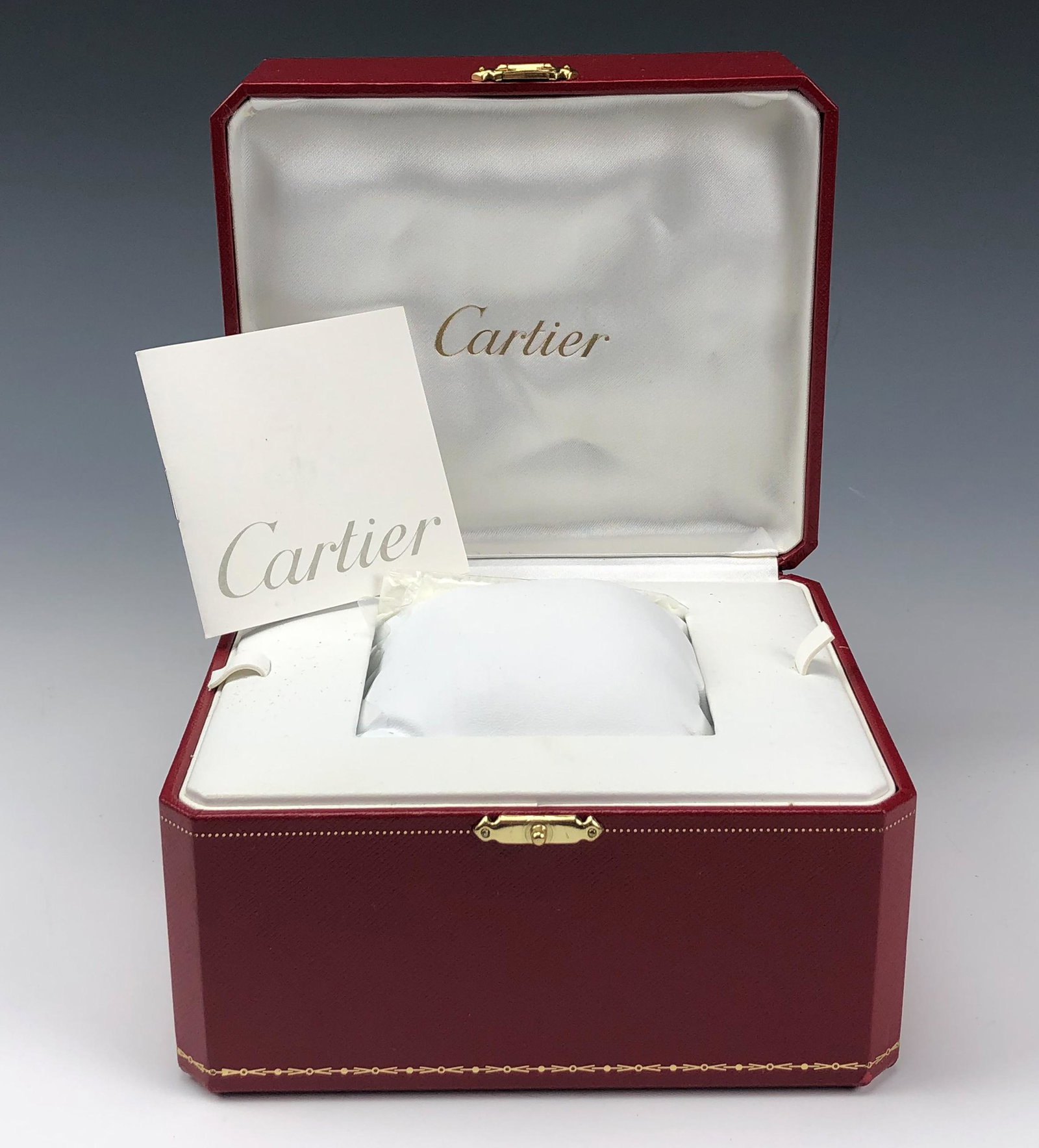 Authentic Cartier Watch Leather Presentation Box: Genuine Cartier Red Leather Wrist Watch Presentation Box. Simple octagonal shape. Nicely hinged with gold toned push button clasp closure. Interiors with white silk lined fabric lining on one side wit
