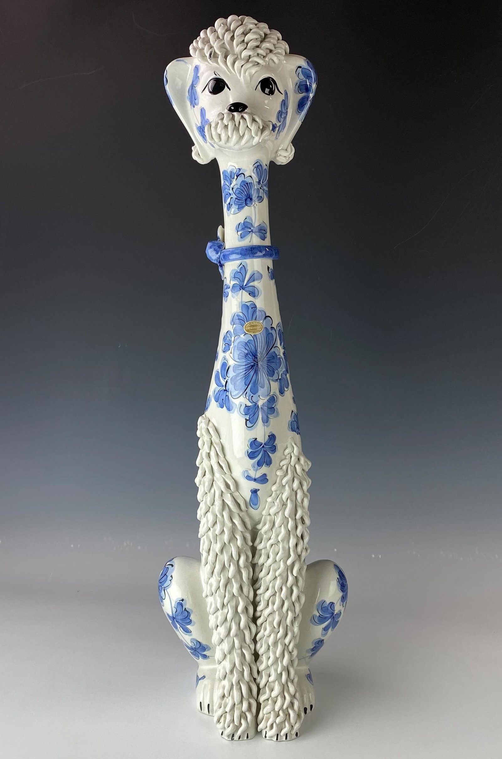 Italian Saks 5th Avenue 29" Spaghetti Poodle Dog: Features a seated K9 poodle dog. Modeled of ceramic pottery with blue floral decorations with applied spaghetti accents and black hand painted eyes, nose, front and back black nails. Signed with paper
