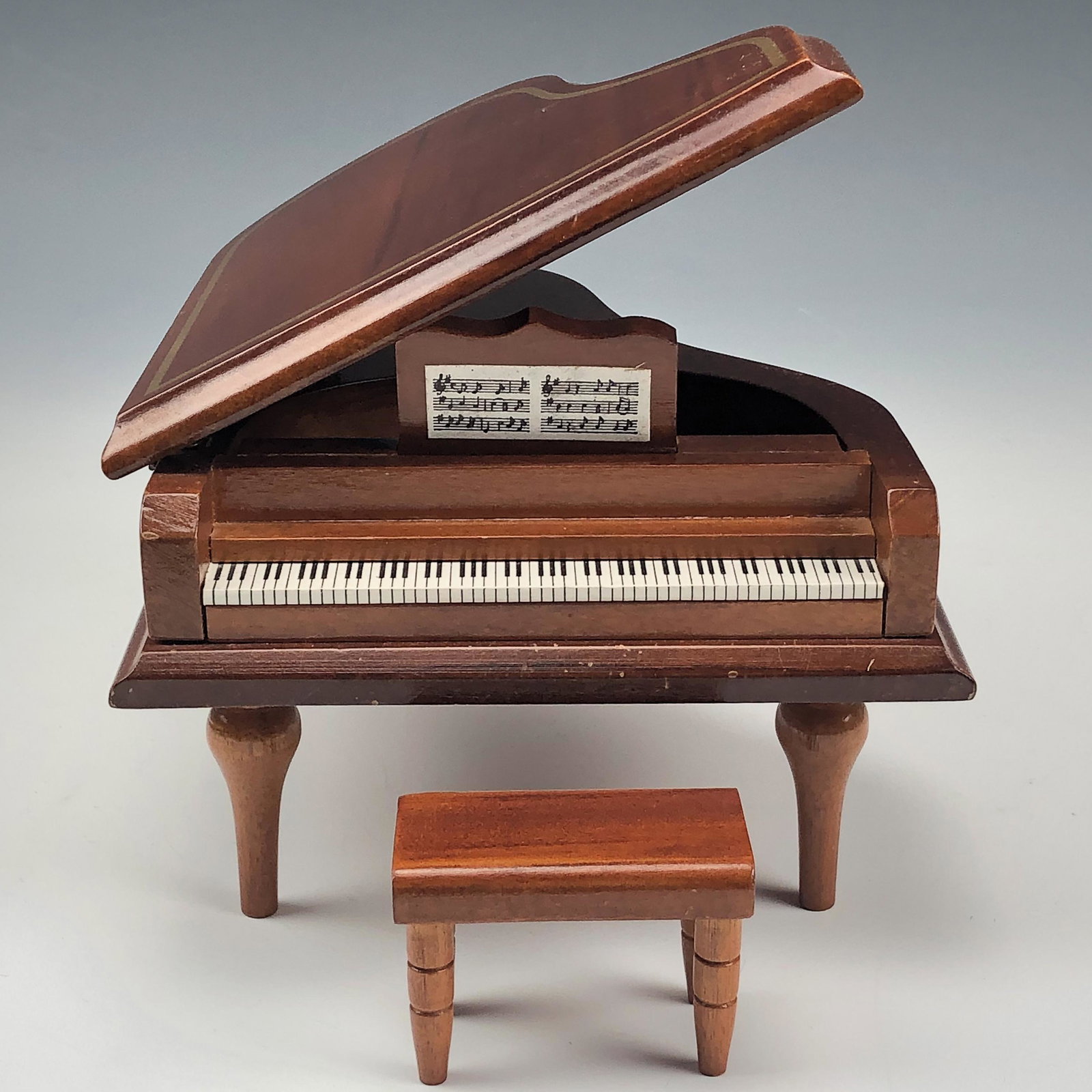 Lefton Mini Miniature Grand Piano Wood Music Box: Nicely constructed wooden music box made by Lefton. Warm graining seen in the wood. Nicely hinged in manner and when the lid is lifted, plays a melodious tune. Comes with it's wooden bench. NO box. Si