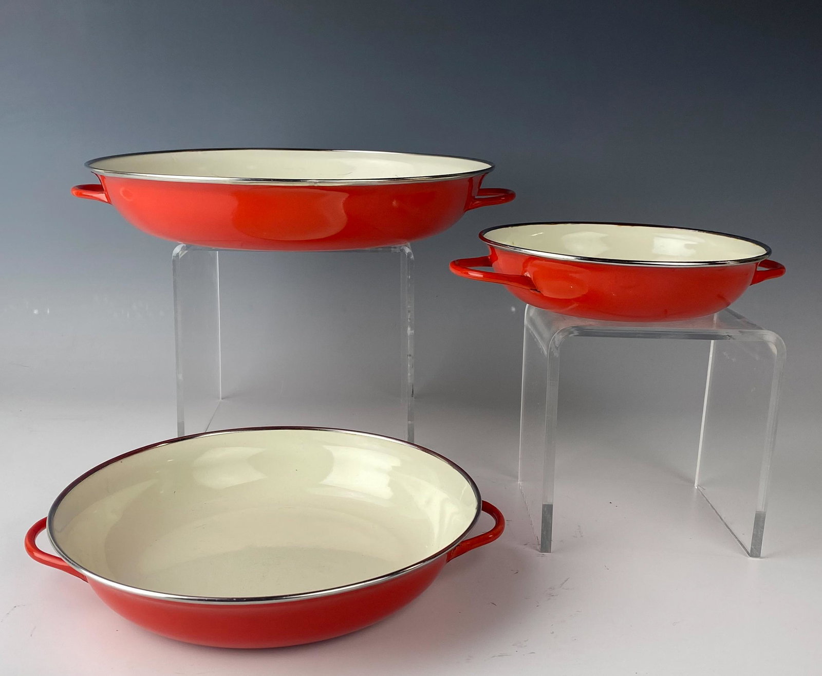 Set 3 Red Enamel Mid Century Modern Nesting Pans: Well modeled and durable cookware / kitchenware articles. Comprised of a set of 3 that neatly nest into each other. Off white colored bodies, the outsides with a bright red coloration. Sturdy handles 