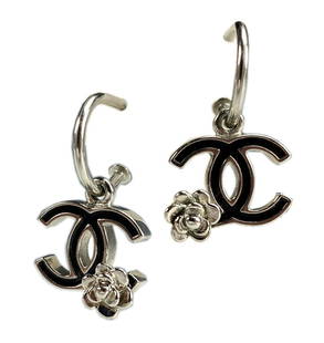 CHANEL Boucles Oreille Silver Enamel Hoop Earrings: Authentic Chanel Silver and Black Enamel Double CC with Signature Chanel Camellia Earrings. Delicate silver hoops adorned with silver double CC black enamel pendant charm with silver camellia accent.