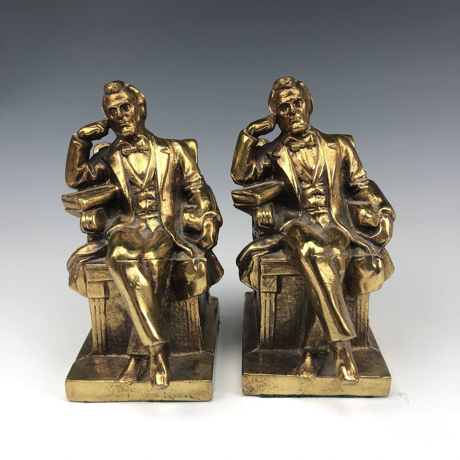 Brass Abraham Lincoln Iconic Chair Seated Bookends: Brass Abraham Lincoln brass bookends. Depicts Abraham Lincoln in the iconic sitting in chair position. Good overall condition with normal storage wear. Measures approximately 7 in. x 4 1/2 in. x 3 1/2