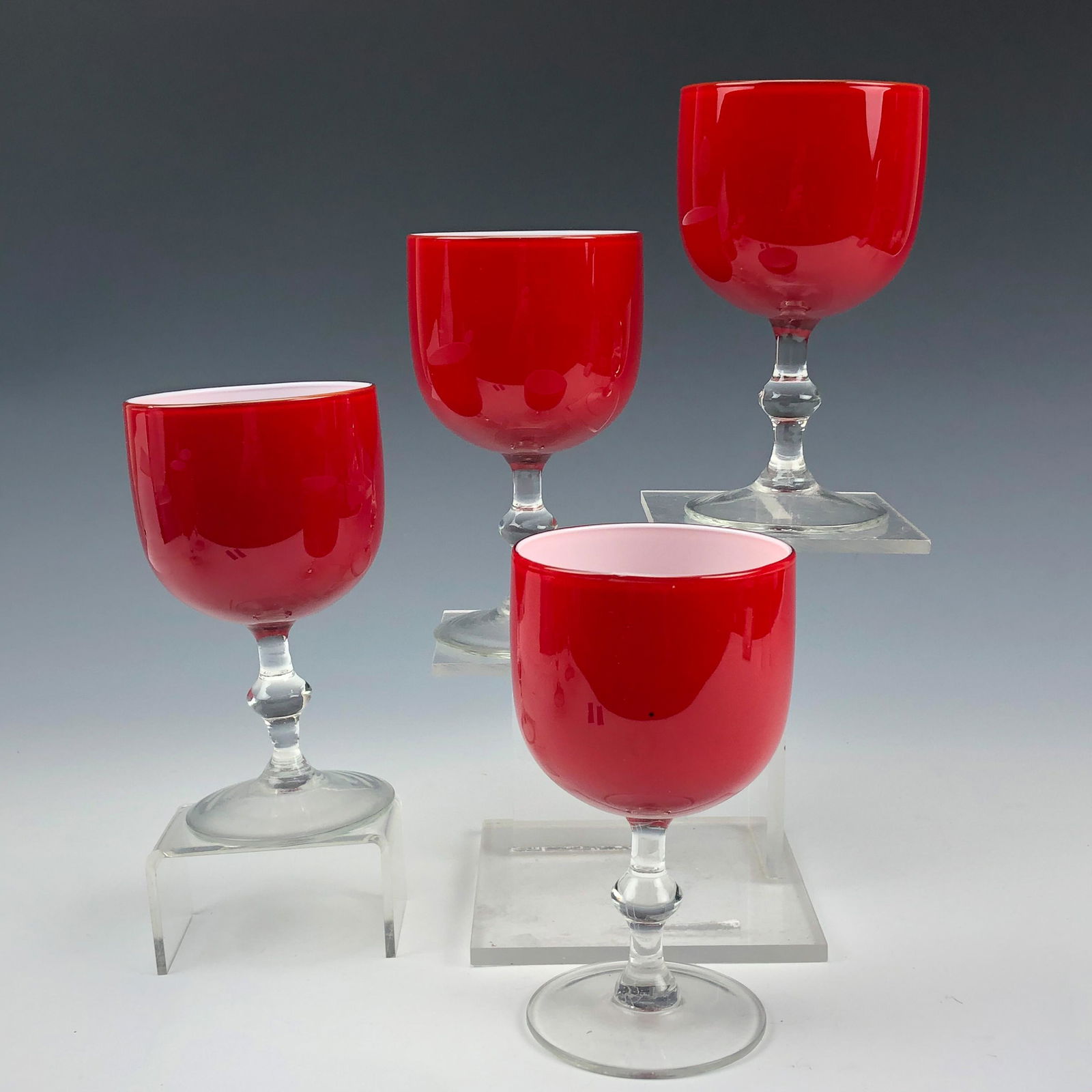 4 Carlo Moretti Mid Century Art Glass Wine Goblets: Established in 1958 in Murano, Venice by brothers Carlo & Giovanni Moretti. Painstakingly mouth blown in manner. Intense blood red exterior masterfully accented by a crisp white cased interior. Clear