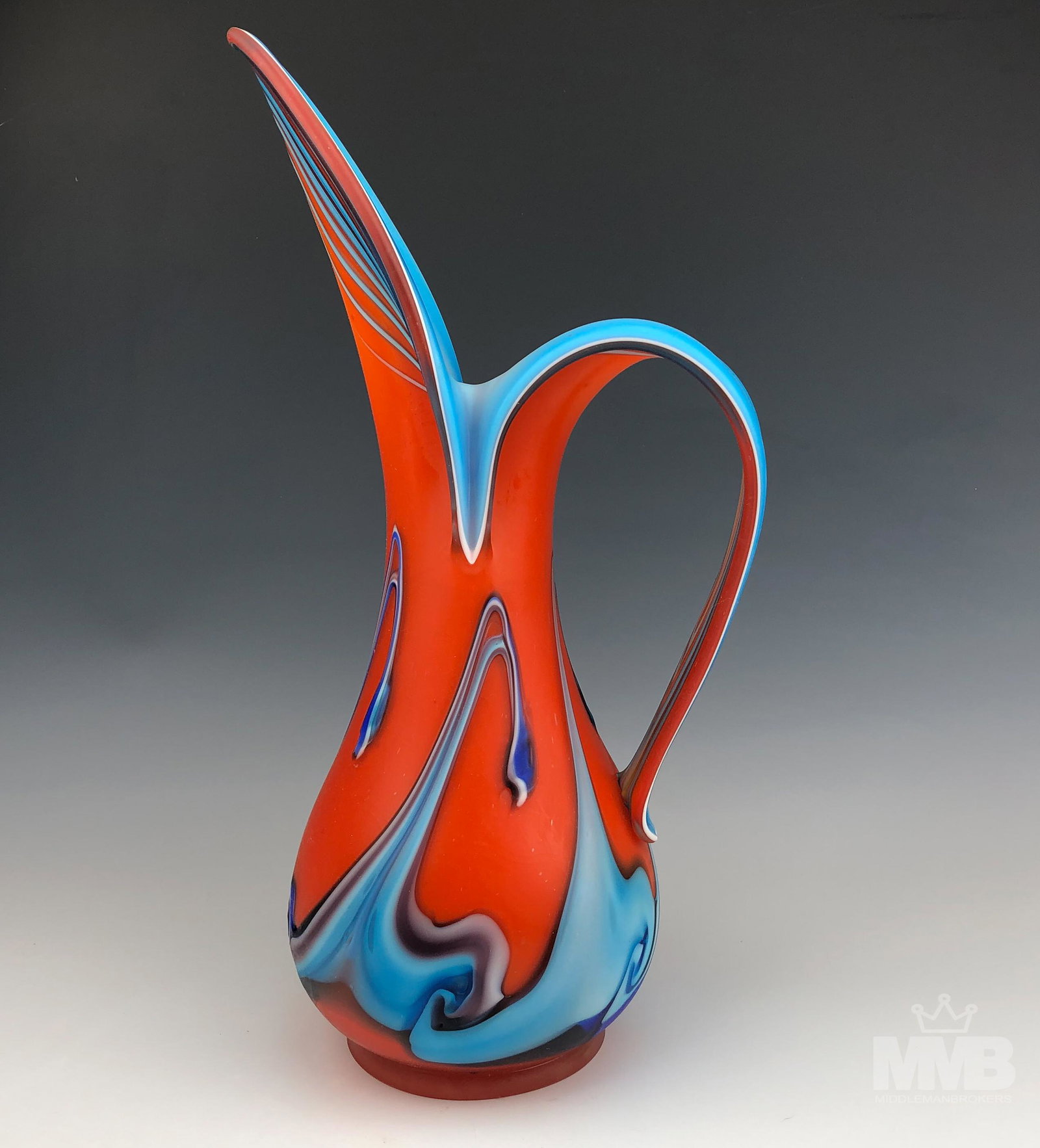 Azerbaijan Russian 11" Orange Blue Art Glass Ewer: Azerbaijan glassware ewer with handle. This hand blown orange art glass has a blue and white inside rim on the handle and circling the vase. Good overall condition with mild storage wear and minor she