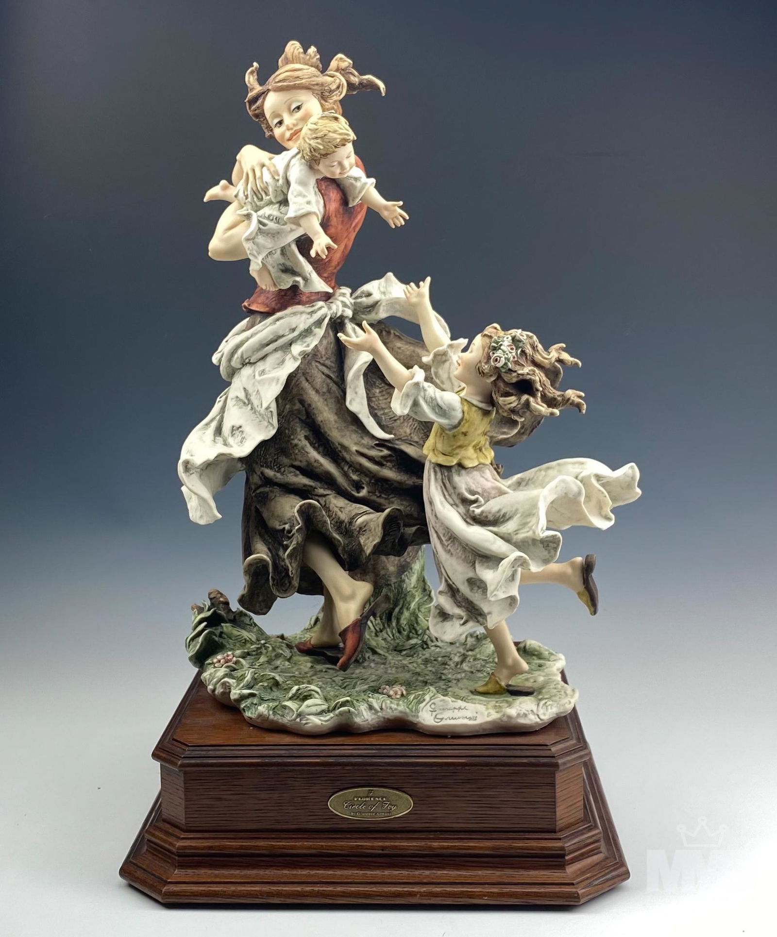 Giuseppe Armani Circle of Joy Limited ED Sculpture: "Circle of Joy" Armani sculpture. Depicts young woman in peasant costume walking and holding rambunctious baby over her shoulder while being trailed by girl child with arms outstretched and flowers in