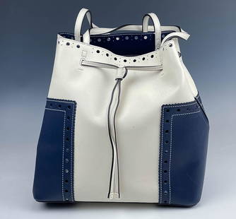 Tory Burch Block T Brogue Drawstring Bucket Tote: Designer Tory Burch white and blue bucket tote. Features colors white and blue with a circle cutout design and a white drawstring and straps. Good overall condition with mild storage wear. Measures ap