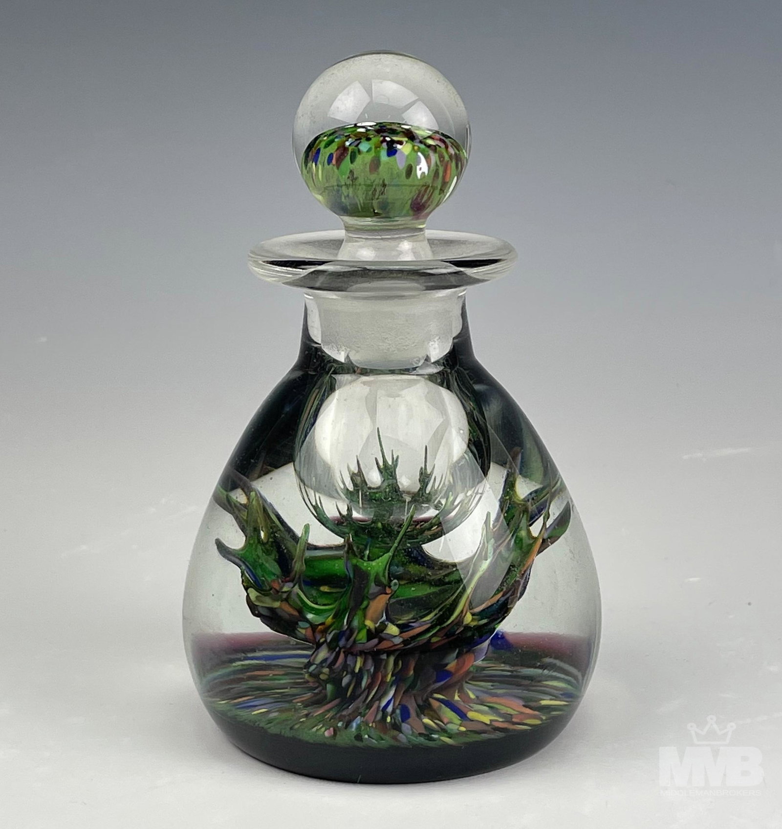 Signed Caithness Scotland Art Glass Inkwell Bottle: Signed Caithness Scottish art glass inkwell paperweight bottle with stopper. Features an abstract multi colored dotted splash design inside clear glass. Marked on bottom. Good overall condition with m