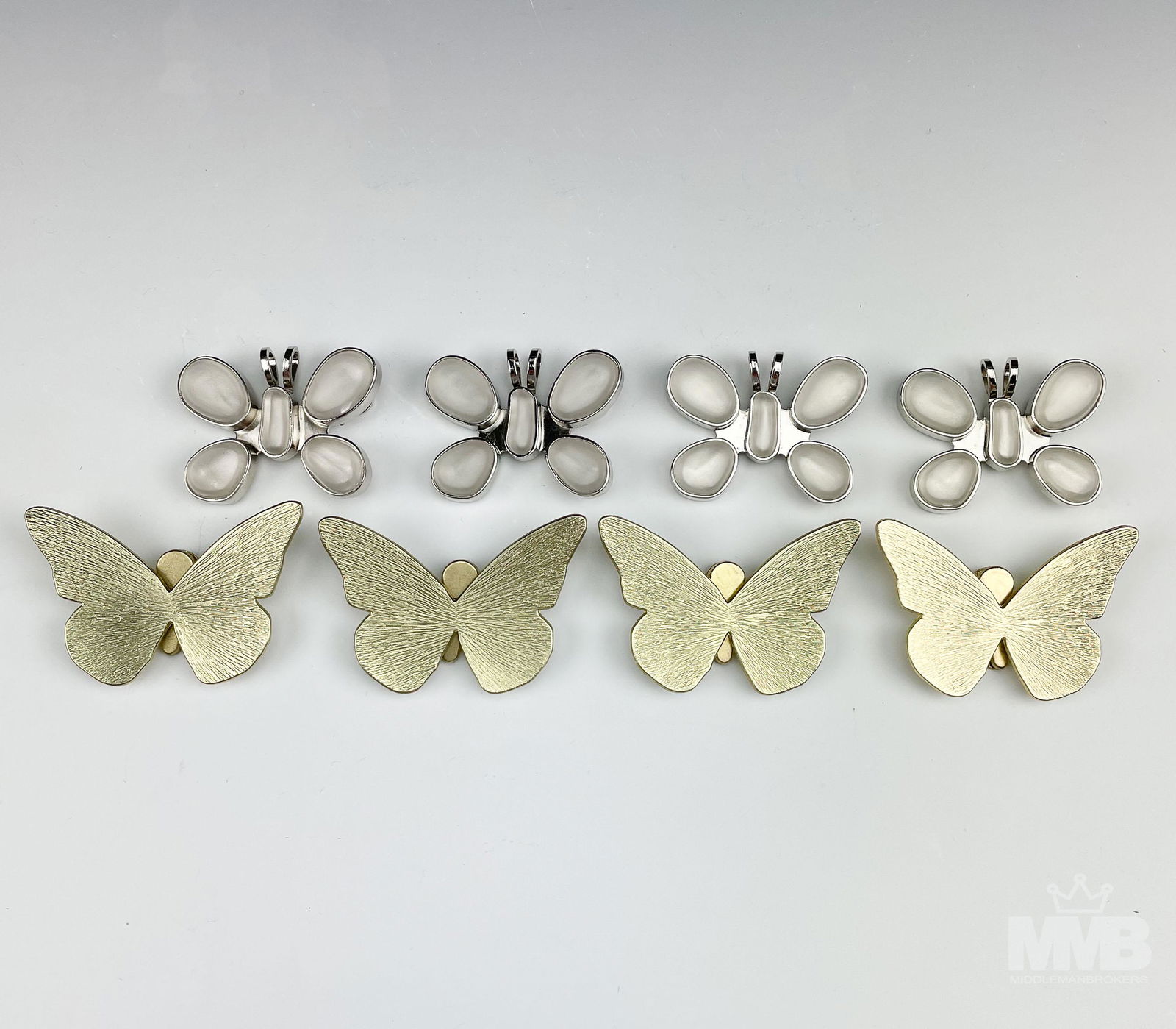 Lot Rebecca Collins & Neiman Marcus Pendant Clips: Lot of 4 Rebecca Collins & 4 Neiman Marcus butterfly pendant clips. The Collins pendants composed of rhodium plated metal and set with large frosted cabochons. The Marcus clips feature a gold tone met