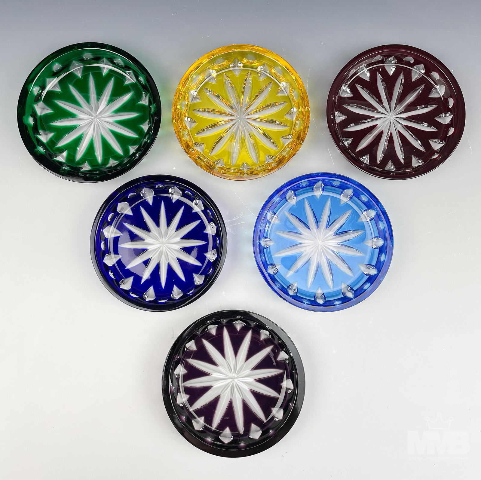 Set of 6 Faberge Xenia Cut Crystal Wine Coasters: Faberge Xenia collection set of six coasters. Features a cut oval, dot and criss cross design in yellow, cobalt blue, emerald green, amethyst, red, and sky blue. Signed. Good condition, having normal