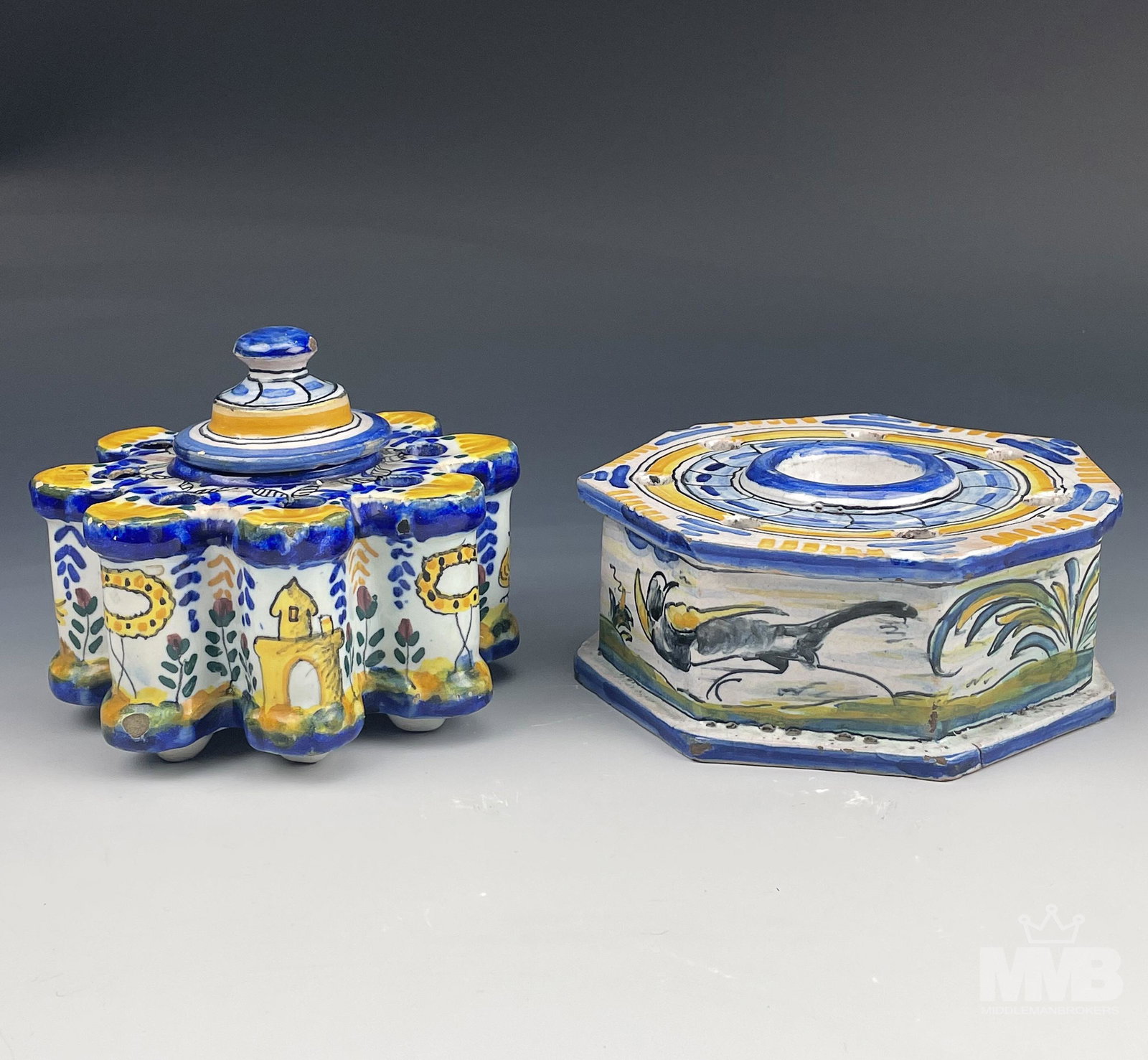 Terracotta Ceramic Pottery Painted Tulipiere Vases: Each graced with multicolored hand painted floral, bird and animal motif against a white ground. One is heptagonal in shape, the other features a scalloped border, is footed. Warm glazed finish to bot