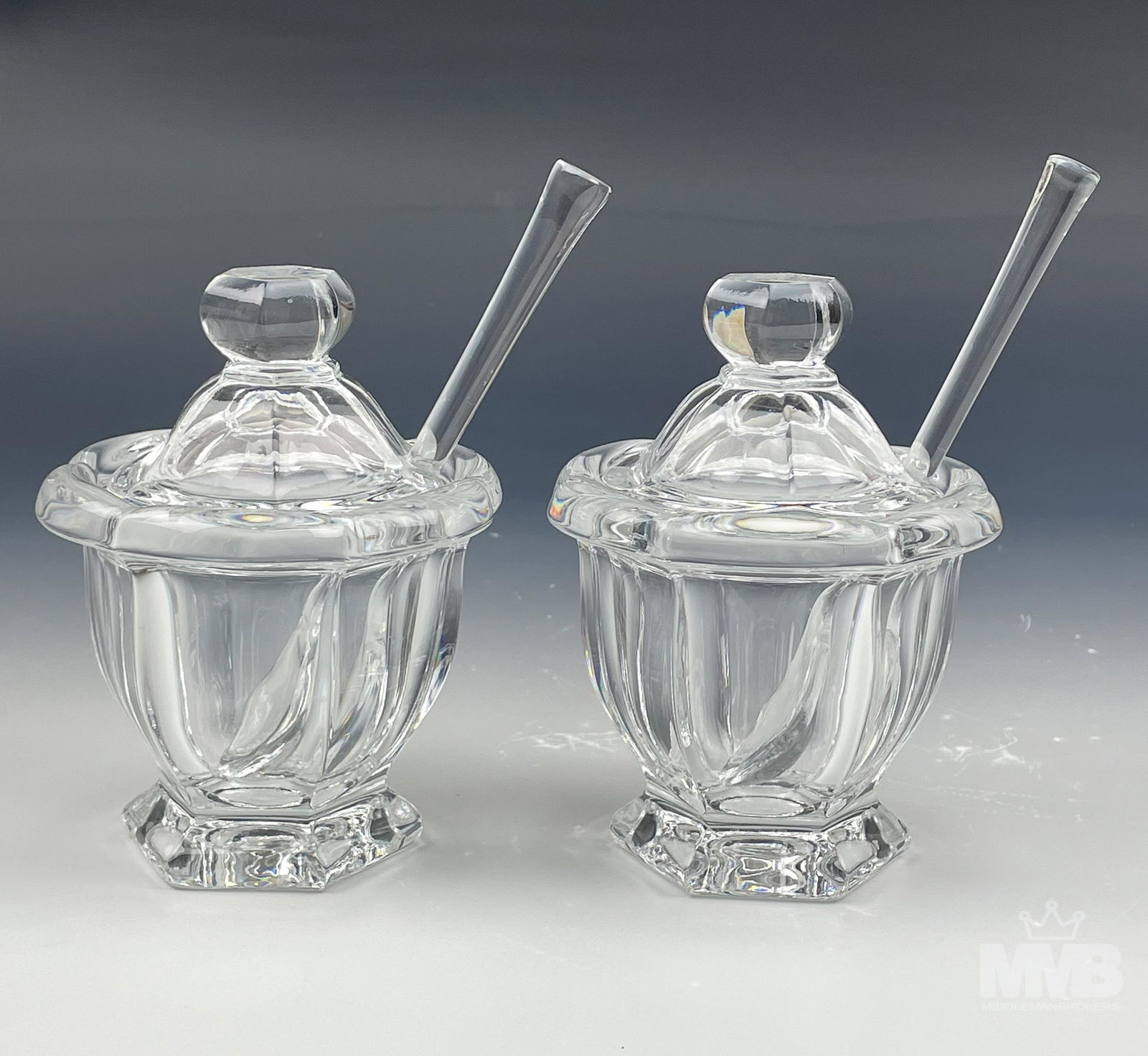 Pair Baccarat Bretagne Crystal Jam Jars w/ Spoons: Pair of Baccarat crystal mustard jam jars with spoons in the "Bretagne" pattern. Both the jars and spoons are acid etched with circular Baccarat maker's mark. Measures 4 1/2 in x 3 1/4 in x 3 1/4 in.