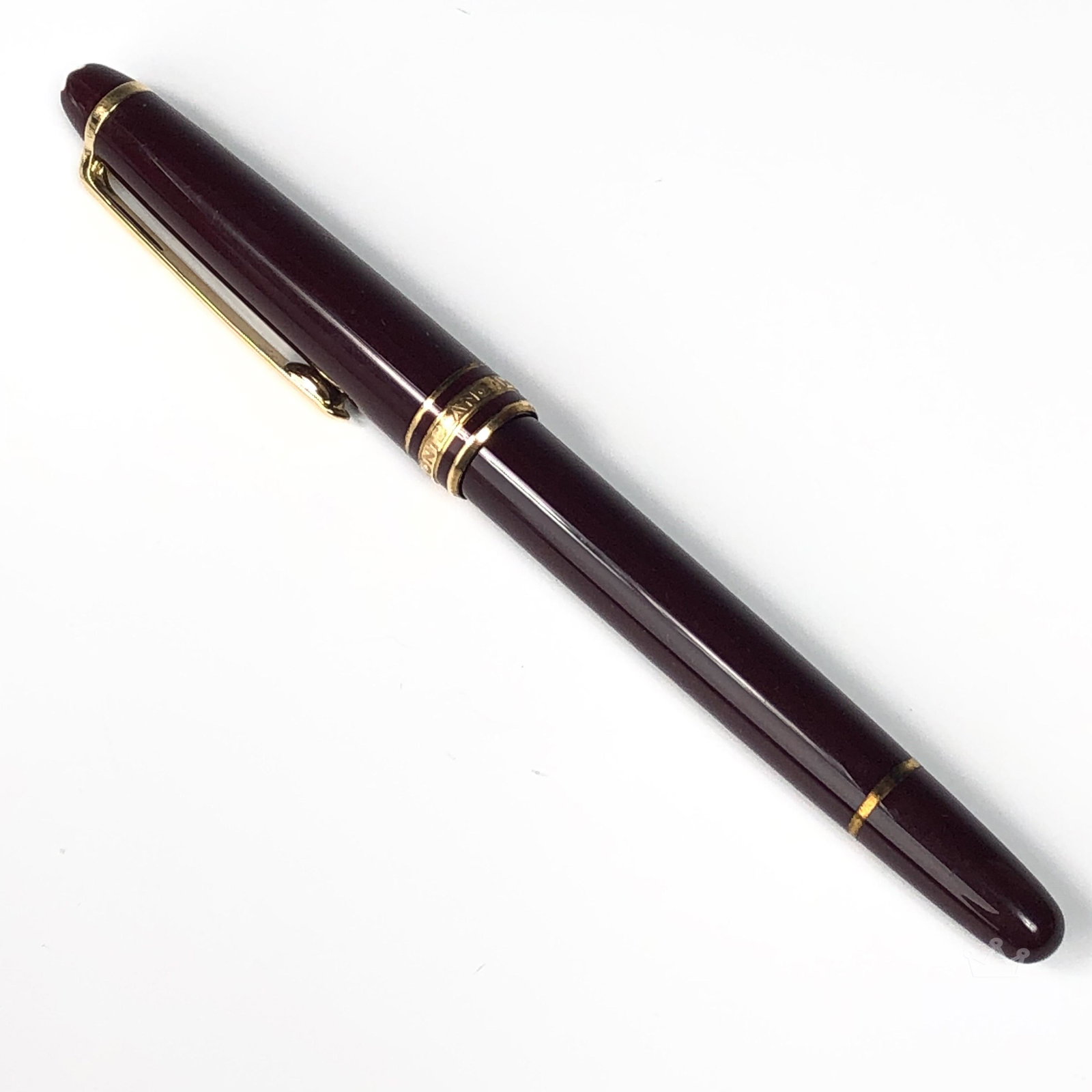 Montblanc Meisterstuck Germany Red Ballpoint Pen: This German luxury ballpoint pen features a cap and barrel crafted in red precious resin inlaid with a white Montblanc emblem. Gold tone clip with individual serial number VI1592400 and the word Germa