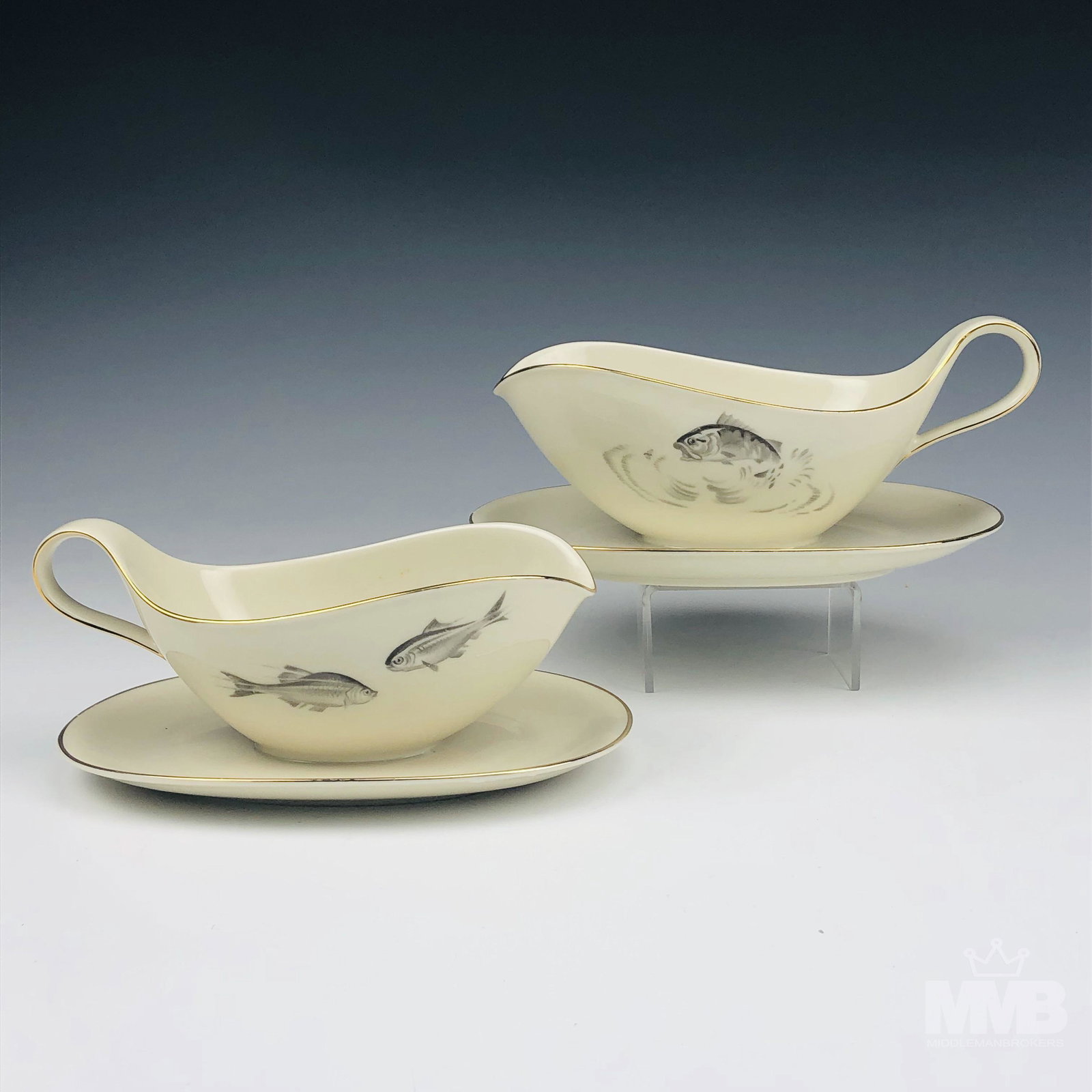2 Heinrich Porcelain Gravy Sauce Boat w Underplate: 2 Heinrich Bavaria German Porcelain gravy sauce boats with attached underplates. Both graced with trout like fish designs on opposite sides against a cream colored ground. Gold trimmed lining along th