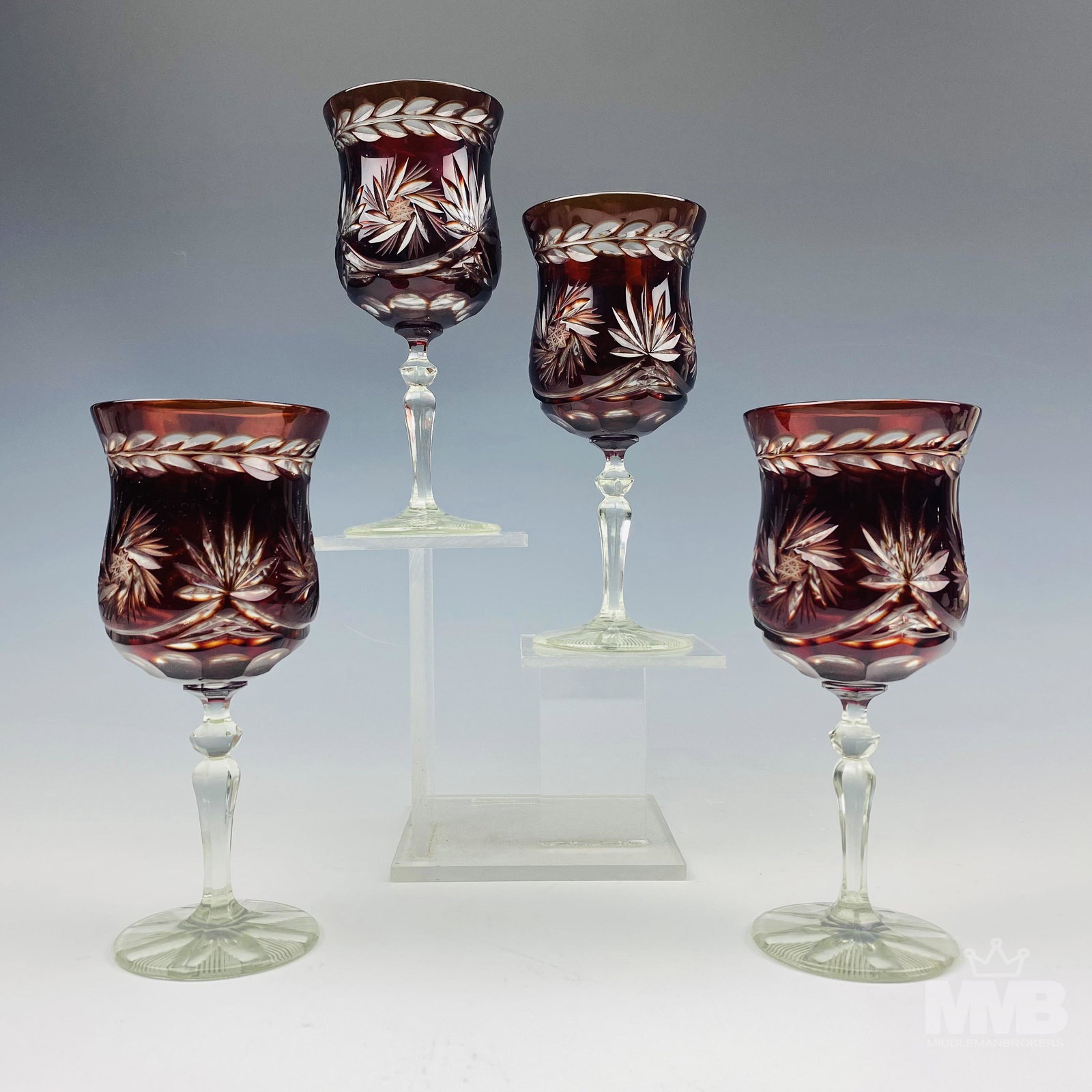 4 Bohemian Czech Crystal Red Cut Clear Wine Goblet: Each graced with an alternating pinwheel and fan form around the body, a laurel leaf featured around the top, against a deep red ground. Multifaceted knob on the tapered stems over spreading circular 