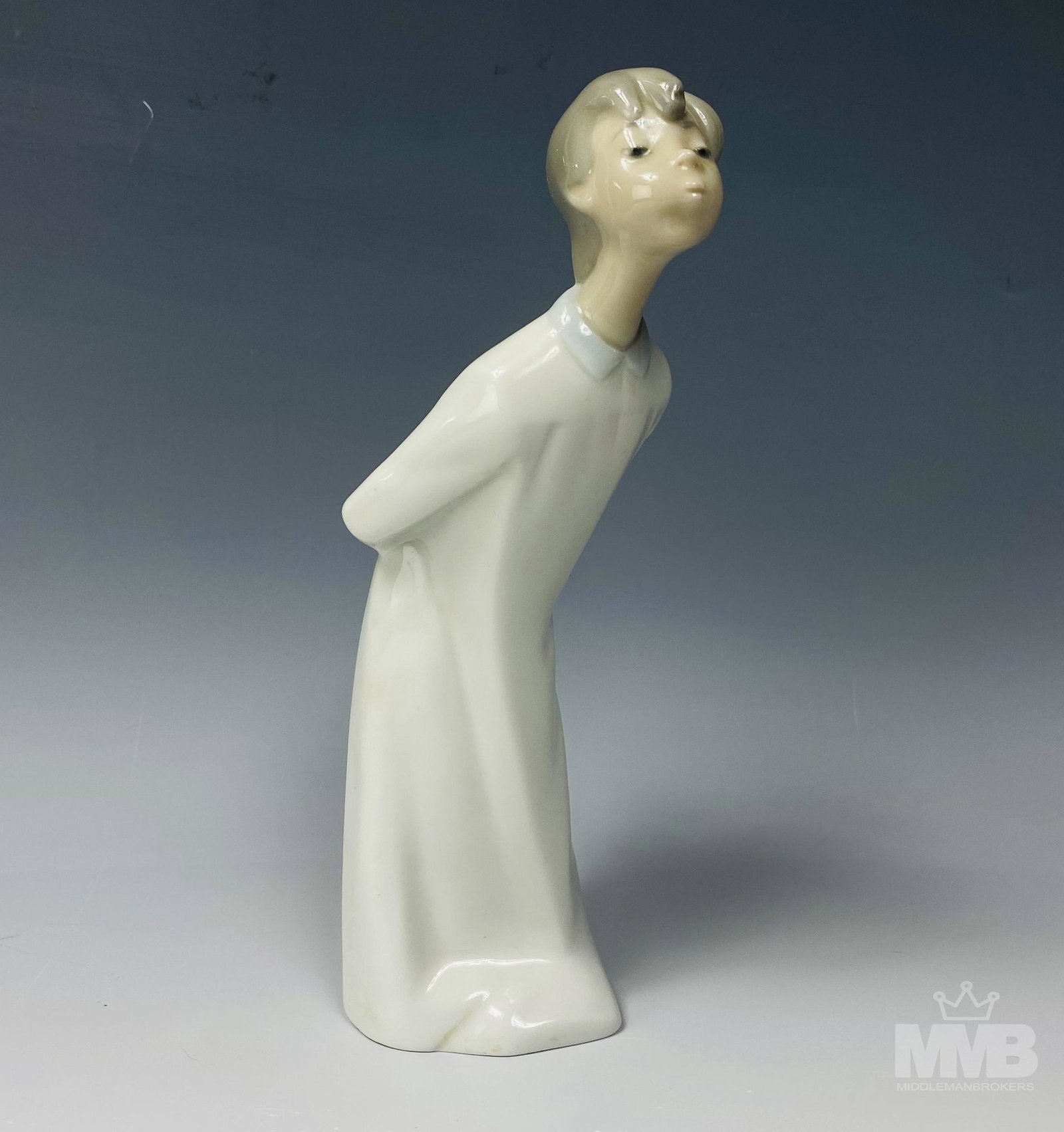 Lladro NAO Spanish Porcelain Kissing Boy Figurine: Figurine by NAO. Crafted of fine quality Spanish porcelain. Features a young boy in nighttime attire learning in a kissing pose. Measures 8 in. x 2 1/2 in x 2 1/2 in. NAO marking on bottom. Good overa