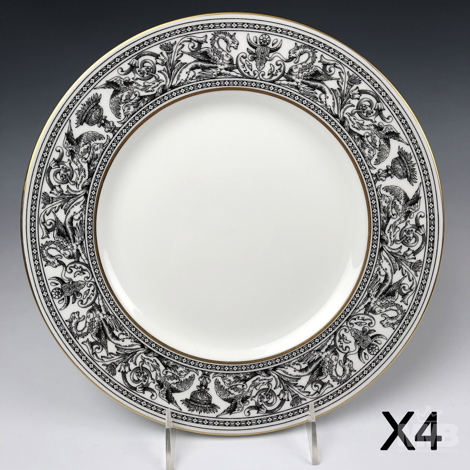 4 Wedgwood England Florentine Black Dinner Plates: Each graced with mythological dragons, phoenix birds and floral decorations around the border, against a crisp white ground with gold trimmed linings. Production years 1959 - 1997. Glazed finish. Good
