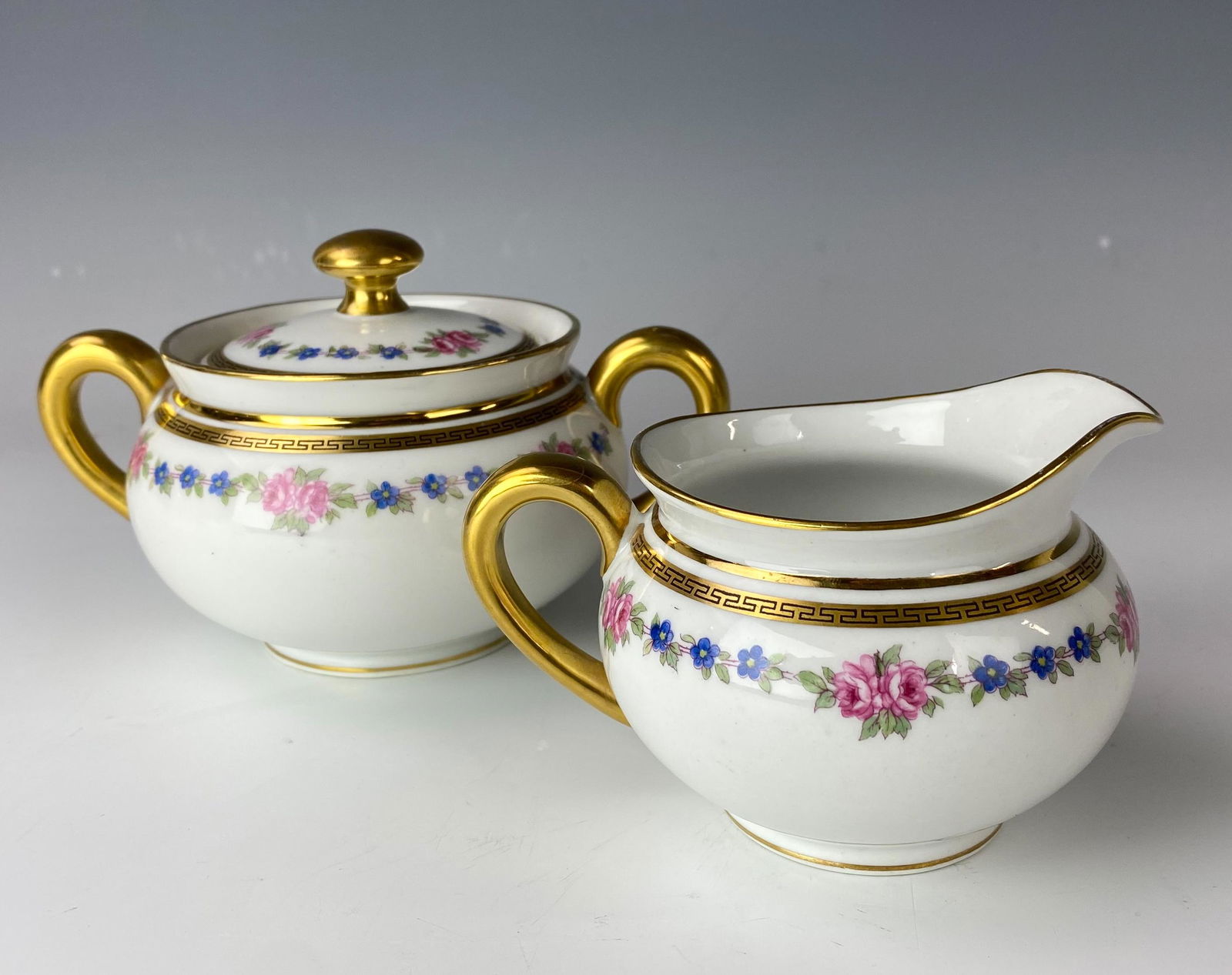 Limoges B&C Porcelain Floral Creamer & Sugar Bowl: Bernardaud & Co B&C Limoges France Porcelain Floral and Greek Key Porcelain Milk Creamer and Lidded Sugar Bowl. Elegantly modeled with rich gold embellishments that nicely compliment both pieces. Each