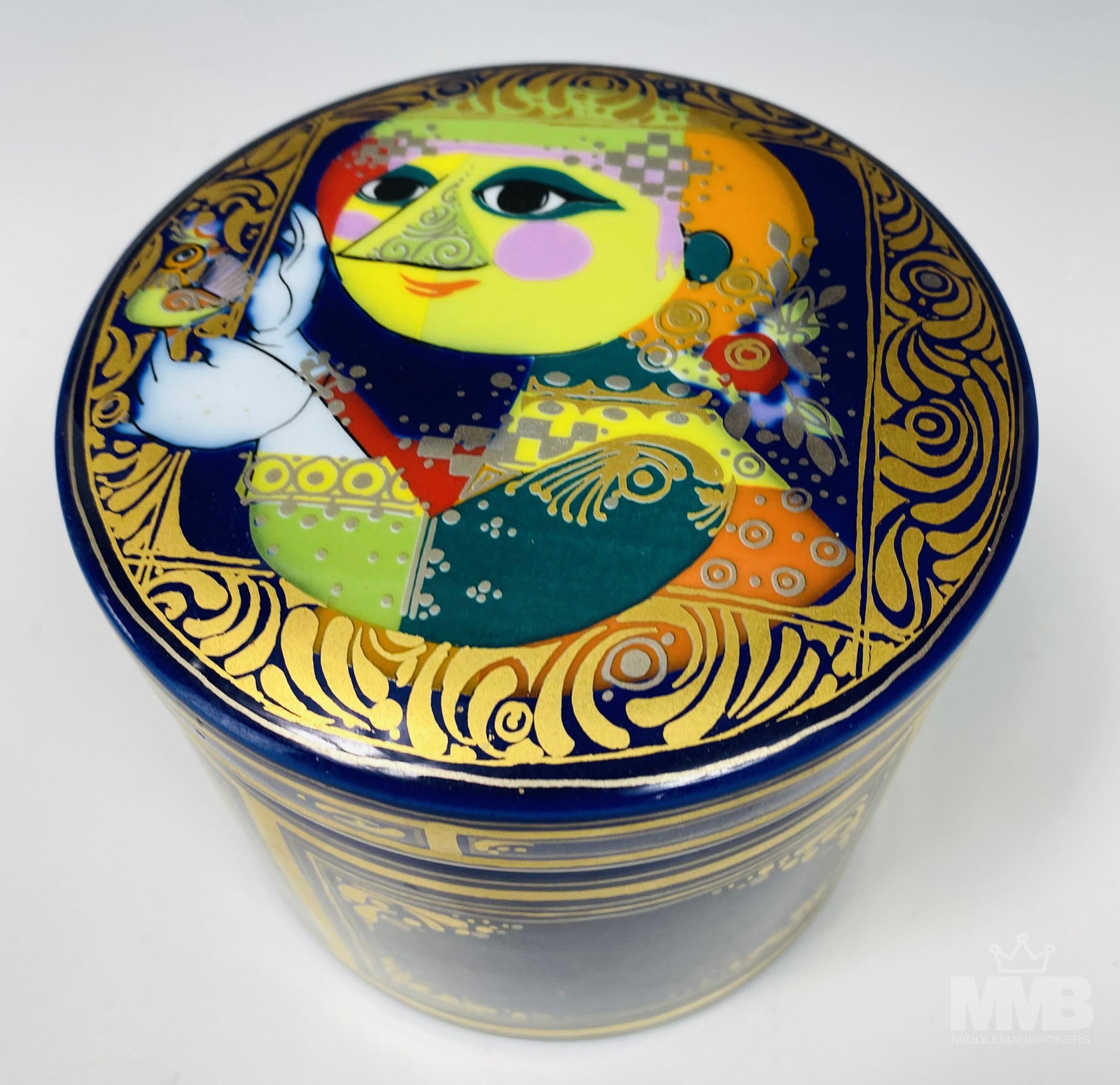 Bjorn Wiinblad Rosenthal Blue Porcelain Canister: Crafted of fine quality German porcelain. Features a figural image holding a bird. Lavish use of gold gilt and bright colors against a cobalt blue background. Signed with the Rosenthal Studio Line bac