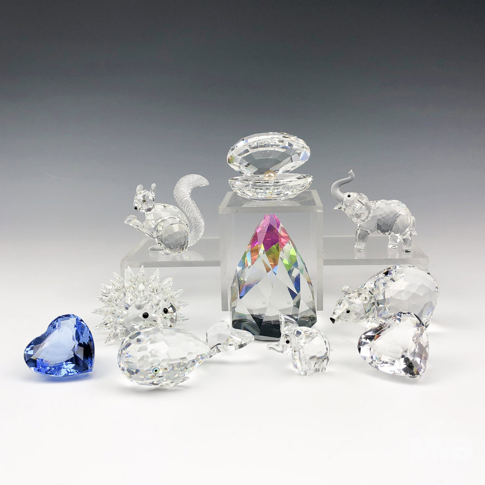 Estate Lot 10 Swarovski Austrian Crystal Figurines: Includes the following. 1 x Polar Bear. 1 x Mini Elephant. 1 x Mini Baby Elephant. 1 x Large Hedgehog. 1 x Clear Heart. 1 x Blue Heart. 1 x Squirrel with Nut. 1 x Whale. 1 x Clam Shell with Pearl. 1 x