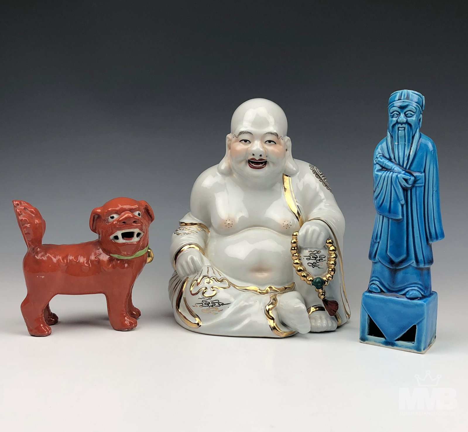3 Chinese Porcelain Buddha Wise Man Dog Figurines: Lot includes the following articles. 1 x happy smiling Hotei Buddha in seated pose holding a gold tone beaded necklace. 1 x blue turquoise standing wise man with a scroll. 1 x a red colored dog in sta