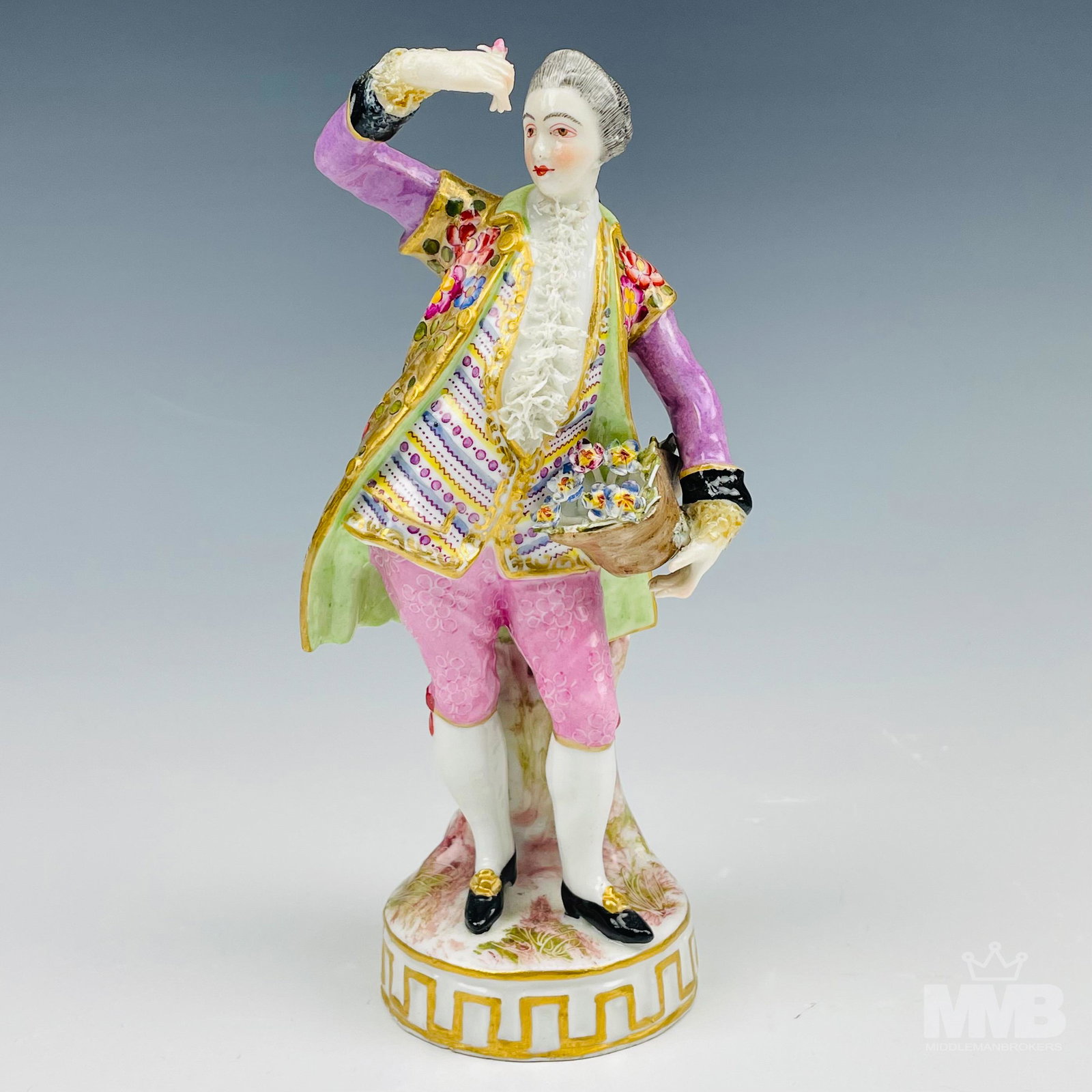 Antique Bourdois & Bloch French Porcelain Figurine: Late 19th century French porcelain figurine depicting a man in Victorian dressed garb, in standing pose, holding a basketful of flowers. Mounted atop a circular base with a geometric influenced gold p