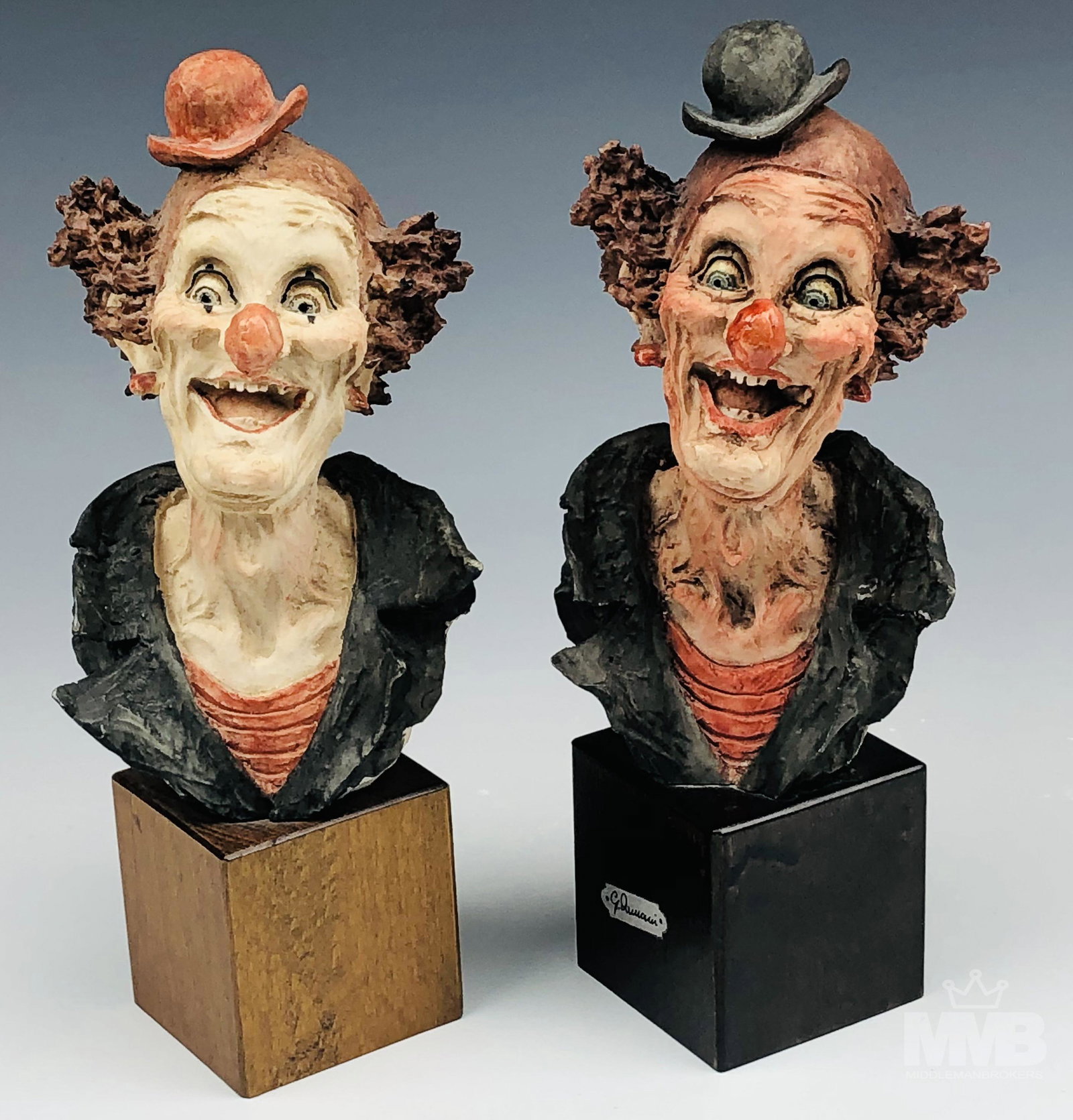 Armani Capodimonte Carnival Clown Sculptures x 2: Subject matter features the busts of 2 smiling and jovial looking carnival circus clowns with hand painted details. Each mounted atop a dark colored wooden base. Signed with impressed G. Armani script