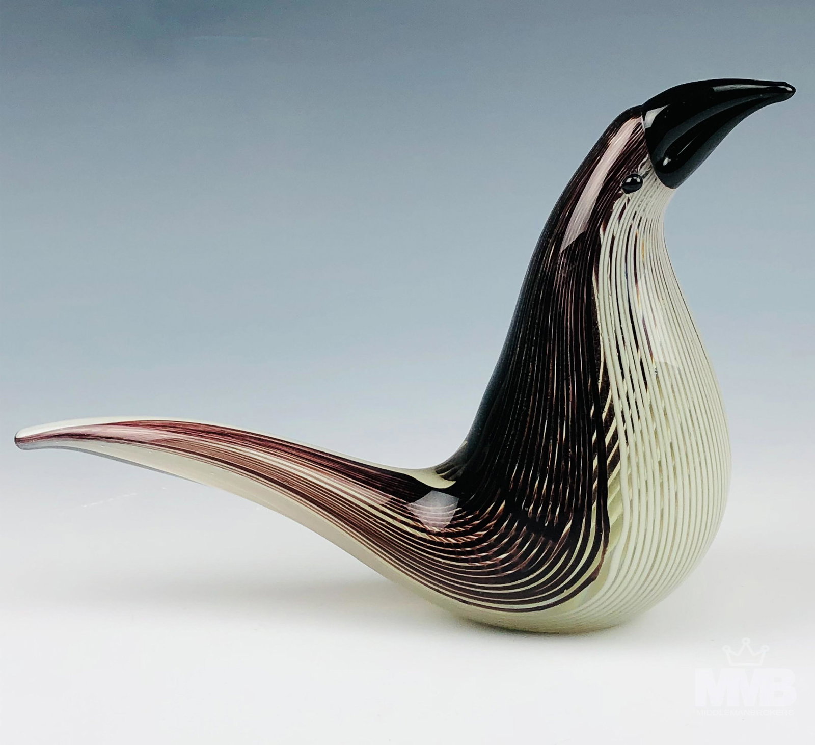 Mid Century Murano Art Glass Toucan Bird Sculpture: Studio hand blown Italian art glass Toucan bird sculpture. Of minimalist design. Graced with an internal brown and white striped pattern cased in clear liquid molten crystal. Applied black glass beade