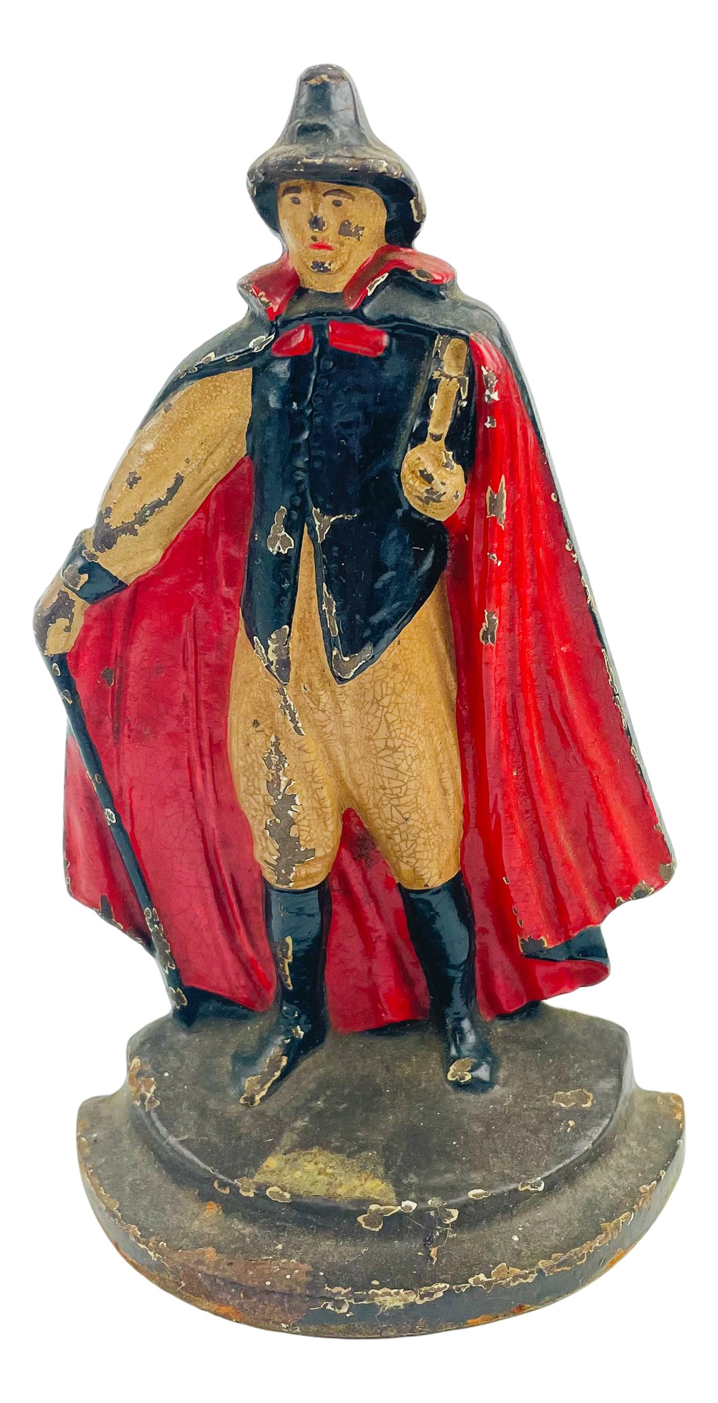 Cast Iron Man with Red Cape & Book Doorstop: Cast iron door stop featuring a man with a red cape and black hat holding a book. No apparent markings, being advertised in the style of Hubley and Bradley & Hubbard. SHIPPING MIDDLEMANBROKERS INC. wi