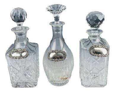 Baccarat Atlantis Crystal Decanters w/ Silver Tags: Baccarat and Atlantis cut crystal glass Barware decanters. Features a set of three cut glass decanters with Sherry, Gin, and Whisky sterling silver chain label tags. One decanter marked on bottom