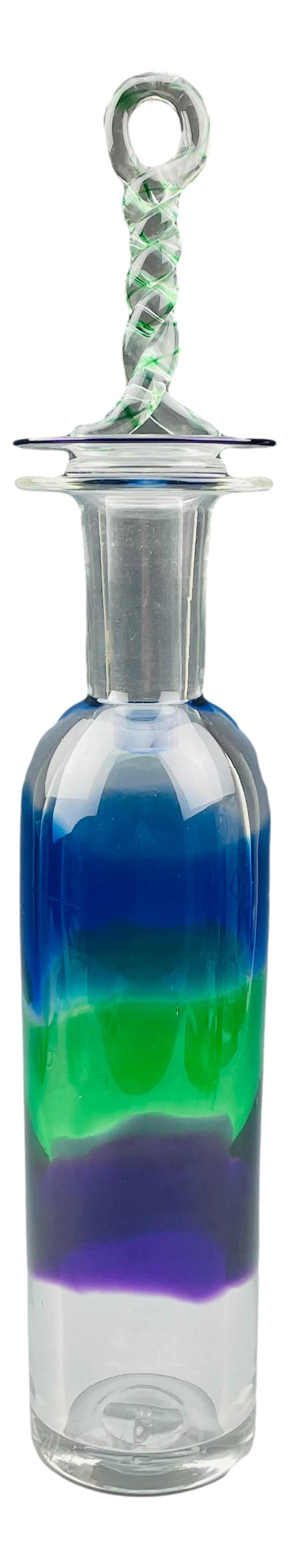 Murano Style Cased Multi Colored Art Glass Decanter: 20th century studio hand blown art glass bar barware decanter. A blue, green and purple cased design graces the mid section against a clear colorless ground. Applied spiral twist stopper with green ri
