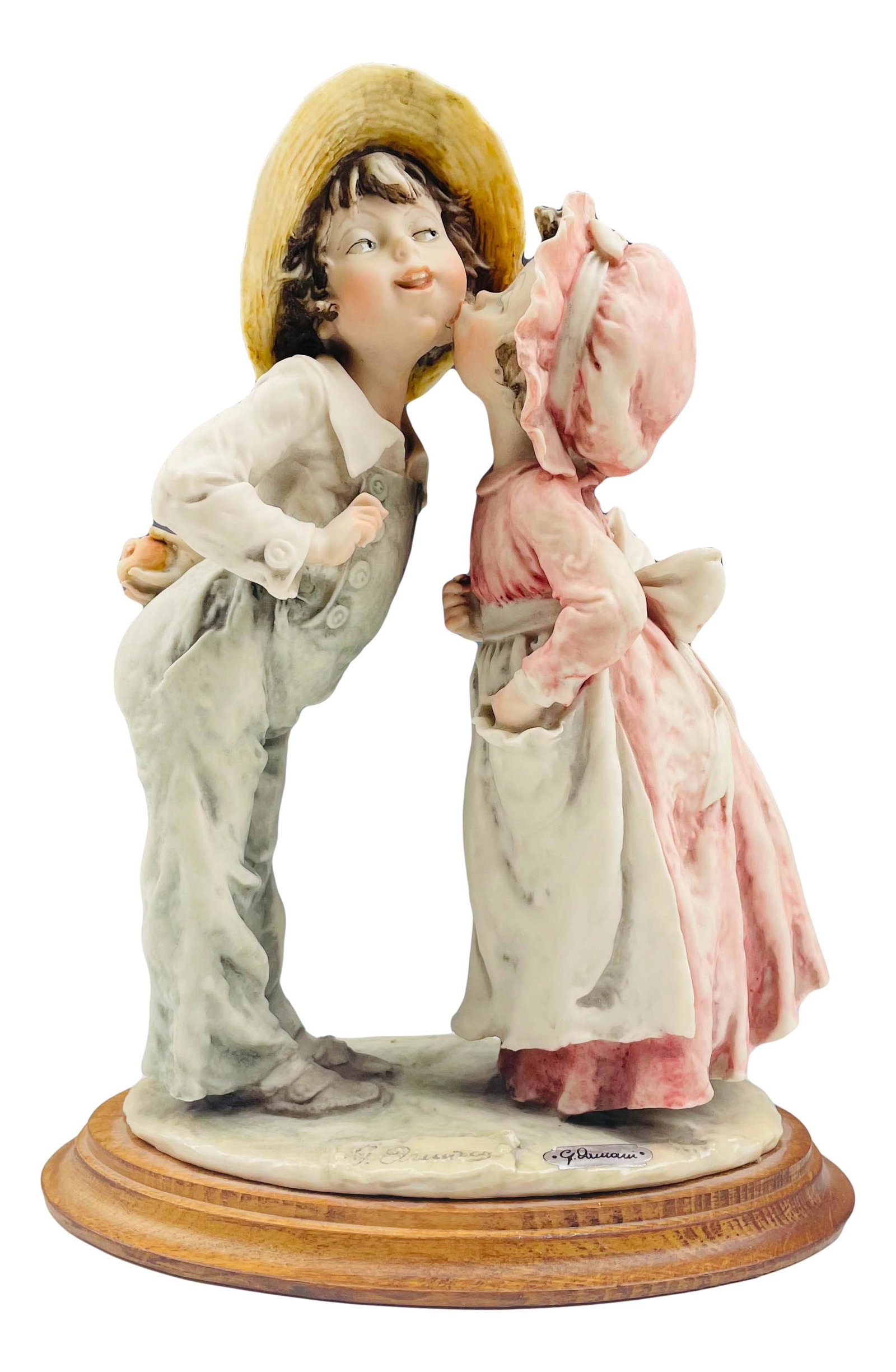 Giuseppe Armani Italy Girl Kissing Boy Sculpture: Giuseppe Armani ( Italian, 1935 - 2006 ) celebrated sculptor and artist. Known for his detailed and intricate figural creations. Subject features a young girl planting a soft kiss on a boy's cheek. Mo