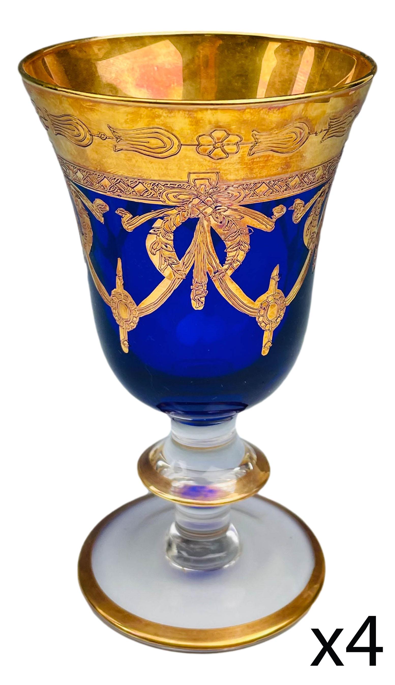 Bohemian Cobalt Blue Gold Gilt Wine Goblet 4pc LOT: 20th century European origin studio Handcrafted glass goblets. The cobalt blue body graced with ornate and lavish gold decorated designs. Rims around the knob stems and the base trimmed with matching 