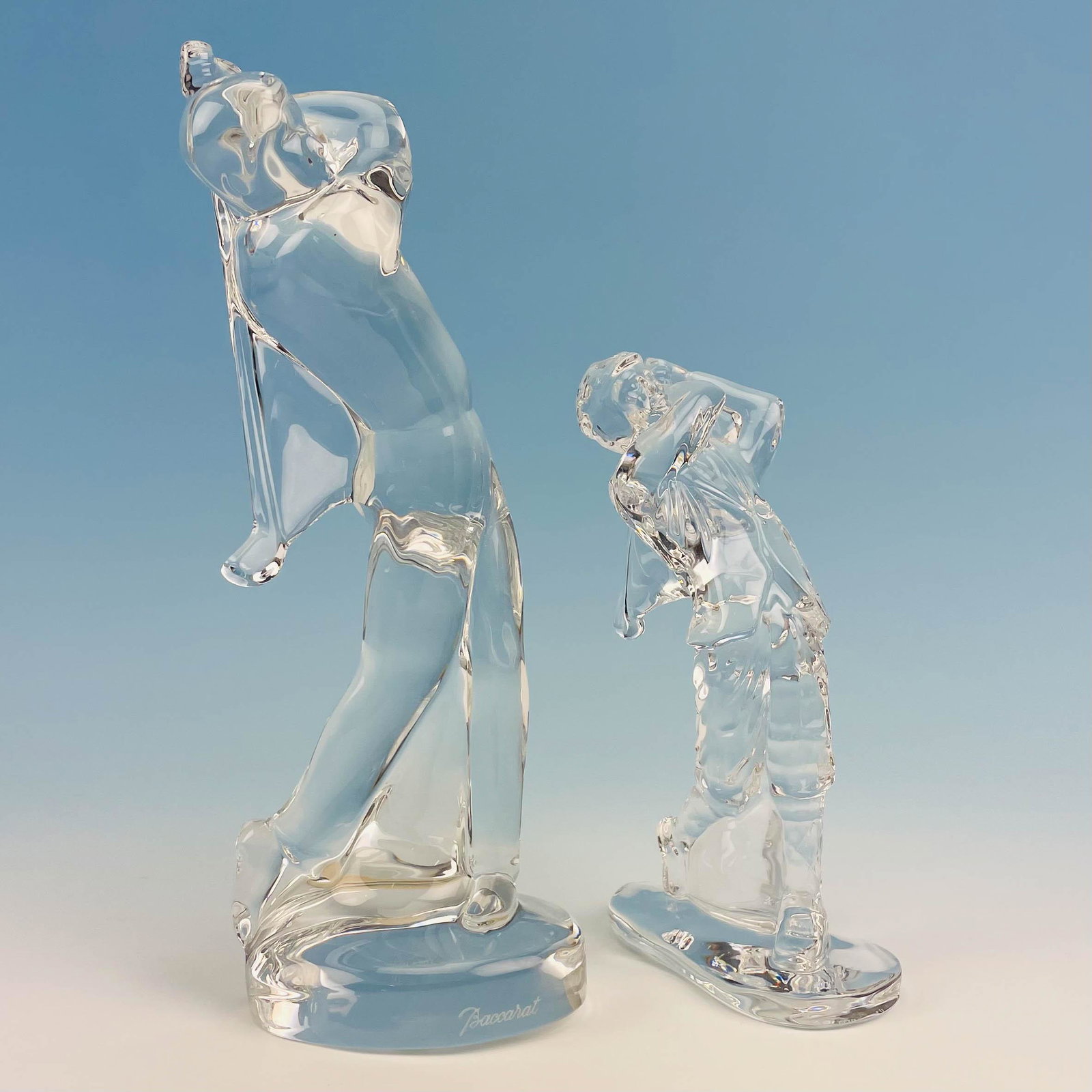 Baccarat & Waterford Crystal Golfer Sculpture Lot: Includes ~ 1 x Waterford crystal art glass golfer figurine. 1 x Baccarat French art glass golfer figurine. Measure 6 3/4" - 9 3/4". Signed ~ stamped Waterford on the smaller sculpture. The larger scul