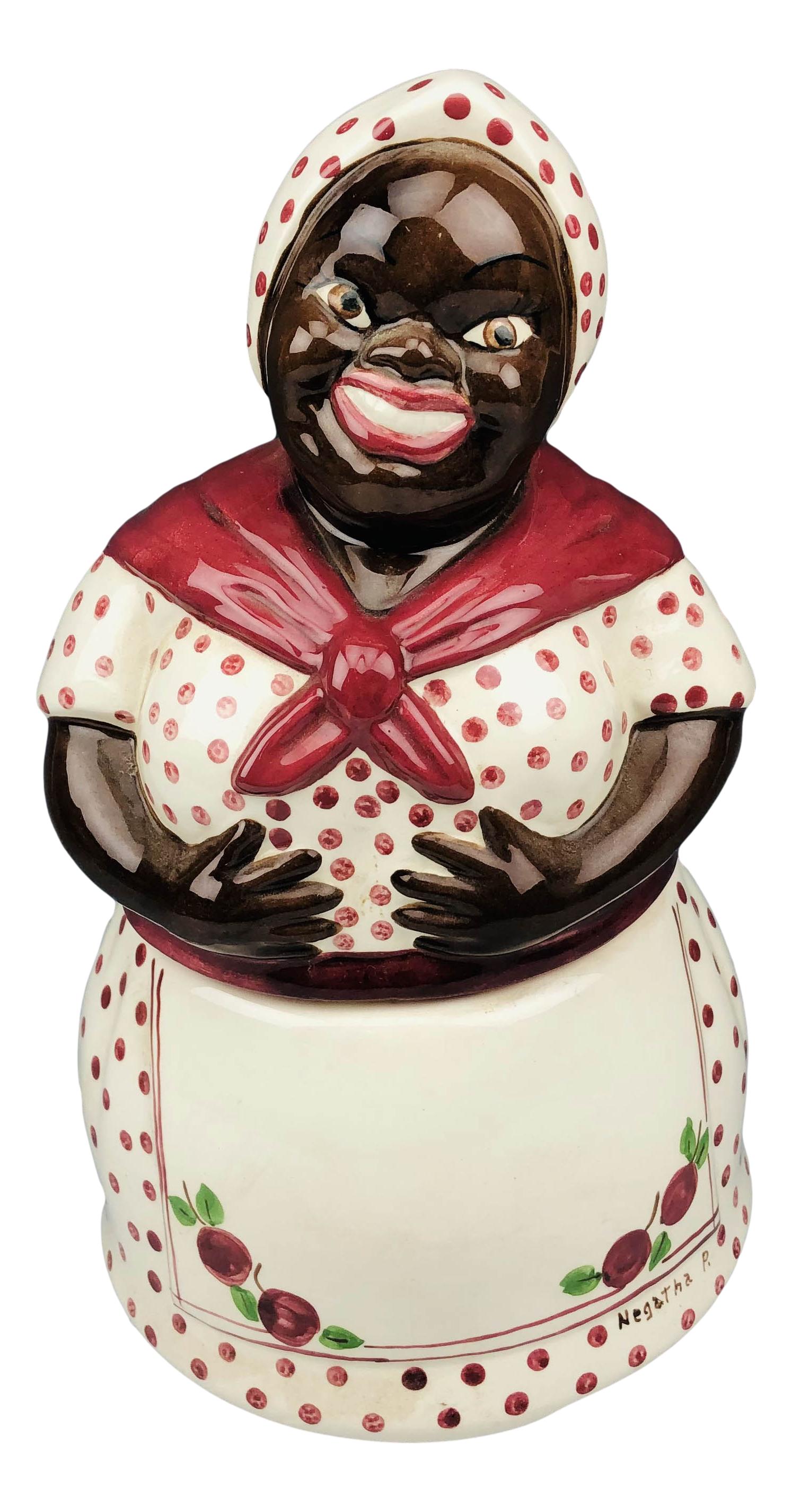 Erwin Pottery Black Americana Figural Cookie Jar: Features a black woman with a warm smile on her cheerful face wearing a maroon polka dot scarf bandana with matching dress, a maroon scarf around her neck, her white apron with cherry patterns, a name