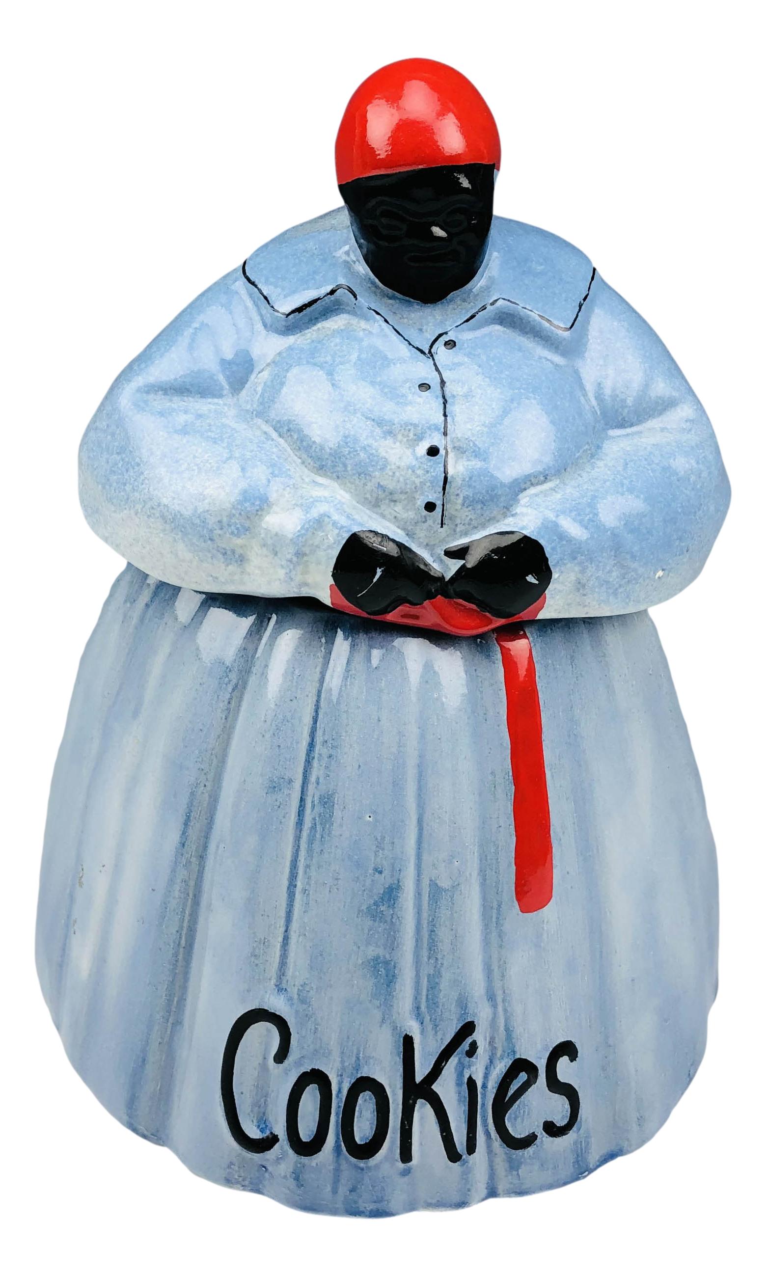 McCoy Black Americana Lady Blue Dress Cookie Jar: 1950's McCoy hand painted ceramic cookie jar featuring a black woman wearing a blue dress with a red sash and bandana. The word "Cookies" in raised lettering lower bottom. Measures 10 1/2" x 8". Signe