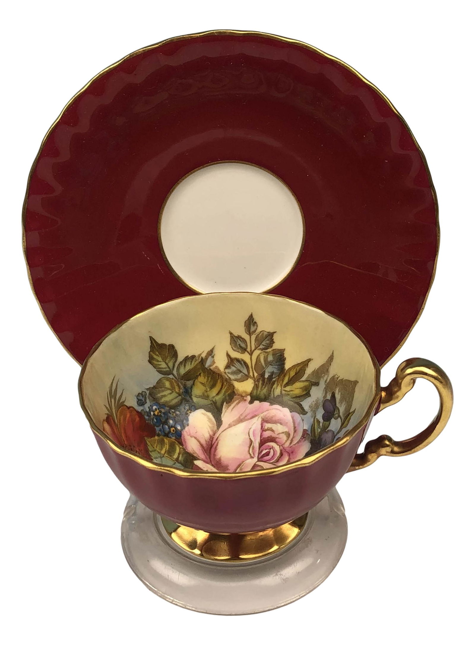 Aynsley Pink Cabbage Rose signed Bailey Cup Saucer: 20th century English bone china tea cup and saucer curio cabinet display set. Interior of the cup features a fully bloomed pink cabbage rose amidst brightly colored wildflowers, against a cream ground