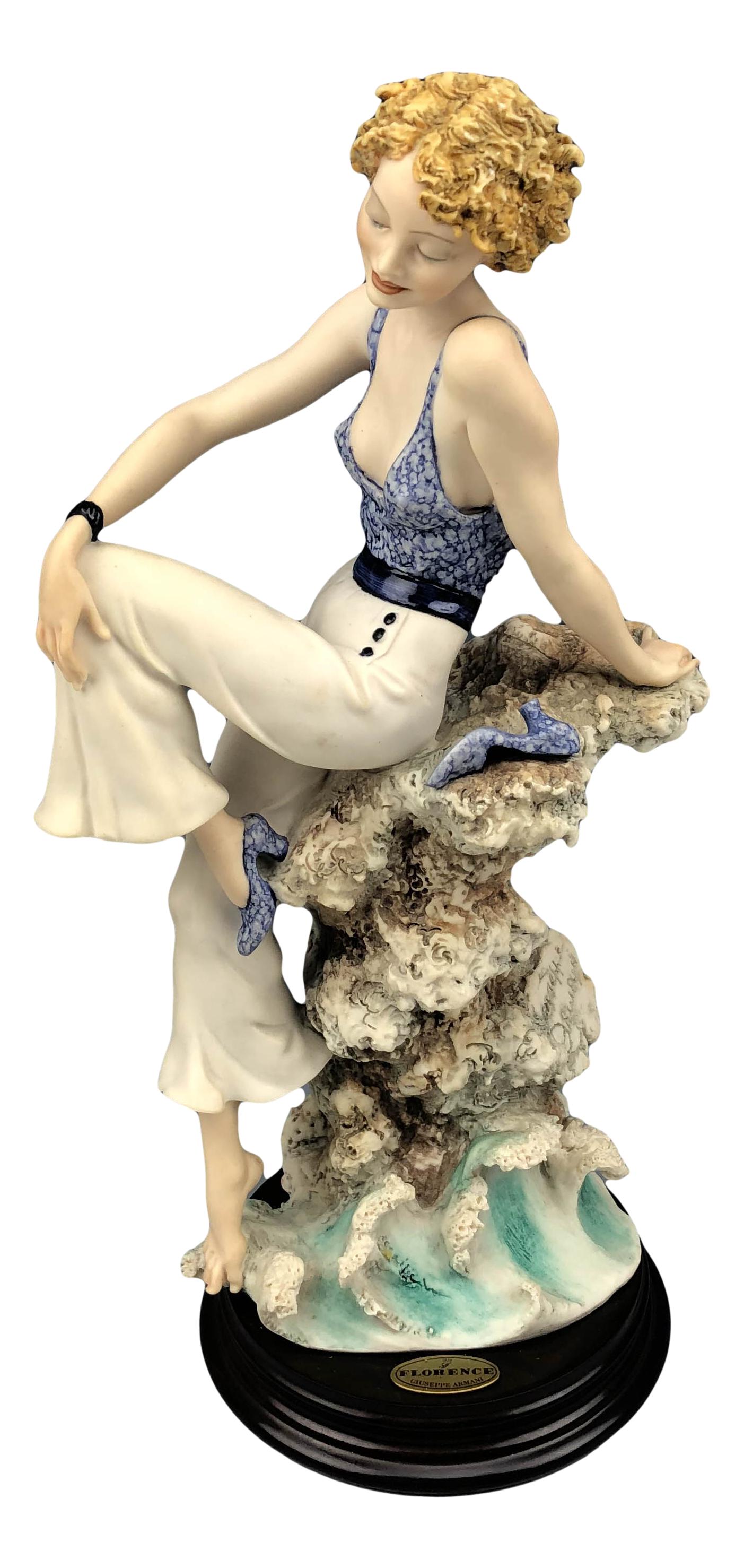Armani Sabrina # 110C Lady on Coral Ocean Figurine: Giuseppe Armani ( Italian, 1935 - 2006 ). Celebrated and internationally respected artist / designer and sculptor. Depicts a young blonde seated on a coral formation, dipping one foot into the waves. 